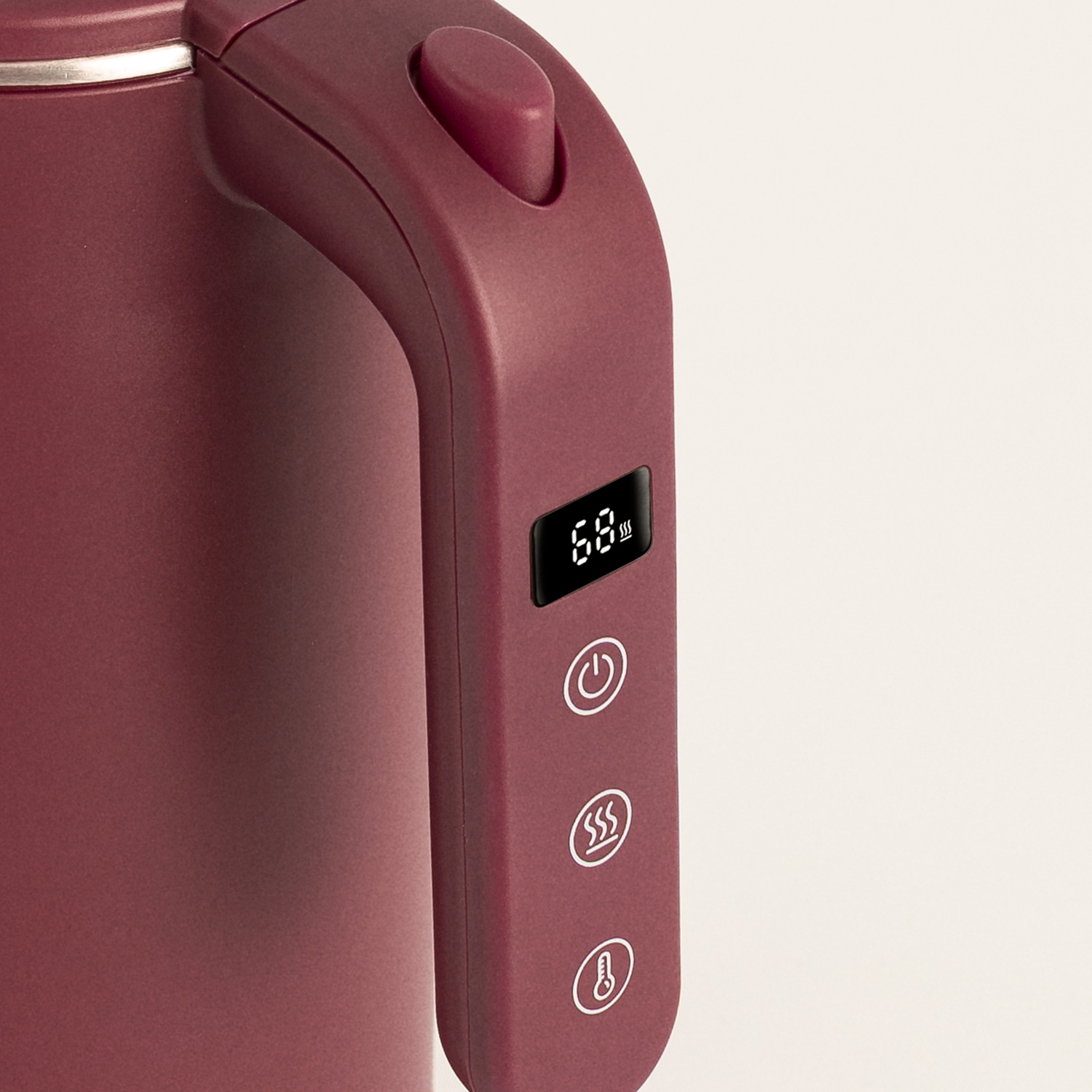 Primer plano del asa de un hervidor rojo oscuro con pantalla digital y tres botones de control.