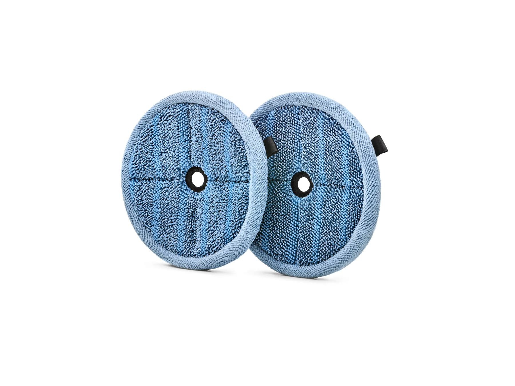 Dos almohadillas de mopa de microfibra azul redondas con un agujero central sobre fondo blanco.