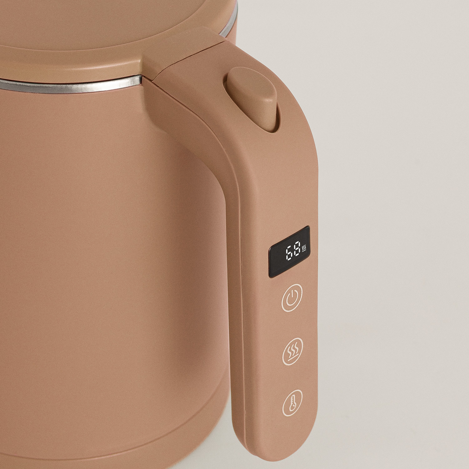 Primer plano del asa del hervidor beige con pantalla digital de temperatura y botones táctiles.