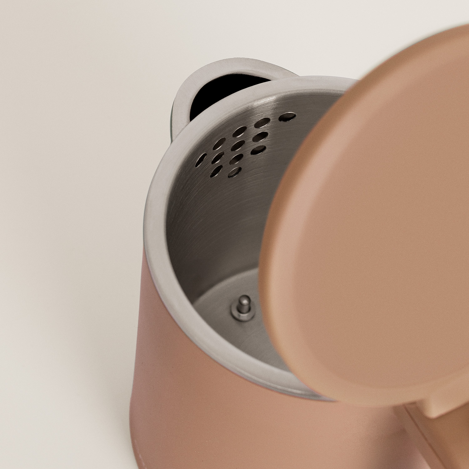 Un hervidor eléctrico rosa abierto que muestra el interior de acero inoxidable con un filtro integrado.