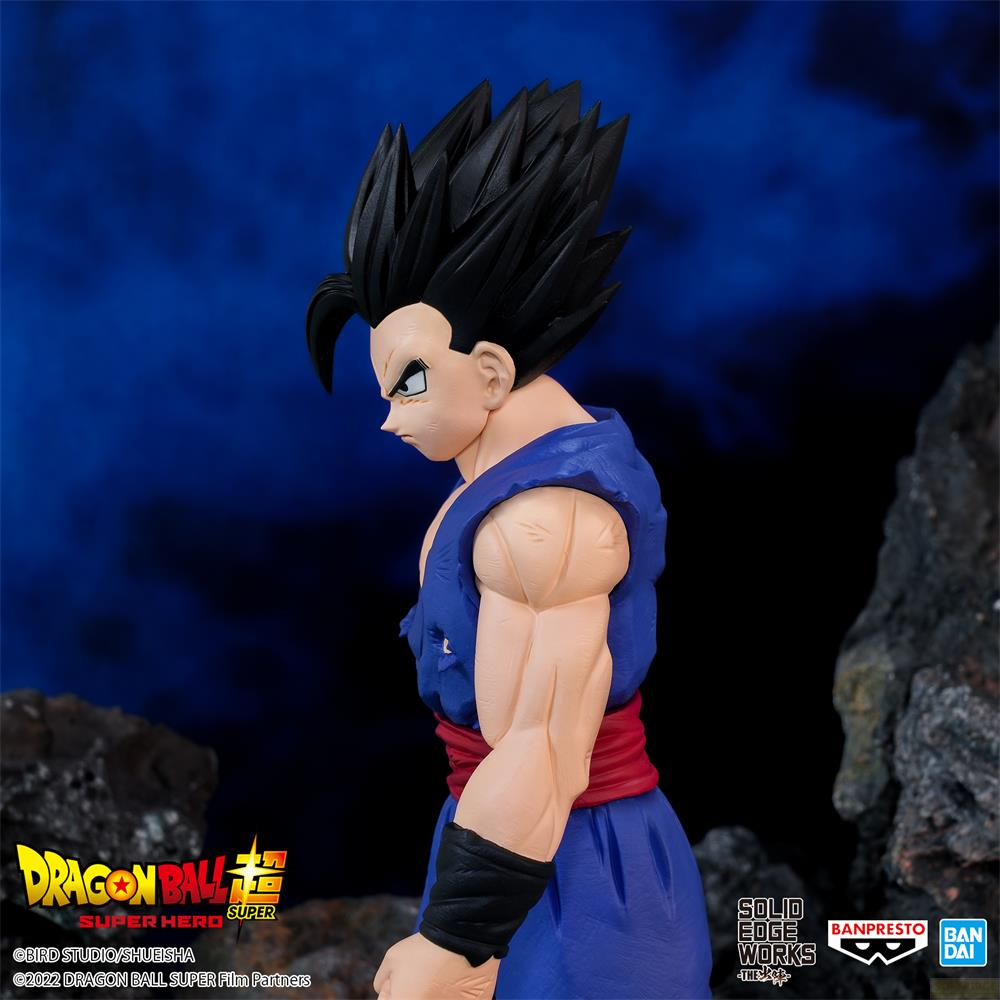 Seitenansicht einer Gohan-Figur in blauem Gi mit roten Gürtel und schwarzen Haaren vor verschwommenem Hintergrund.