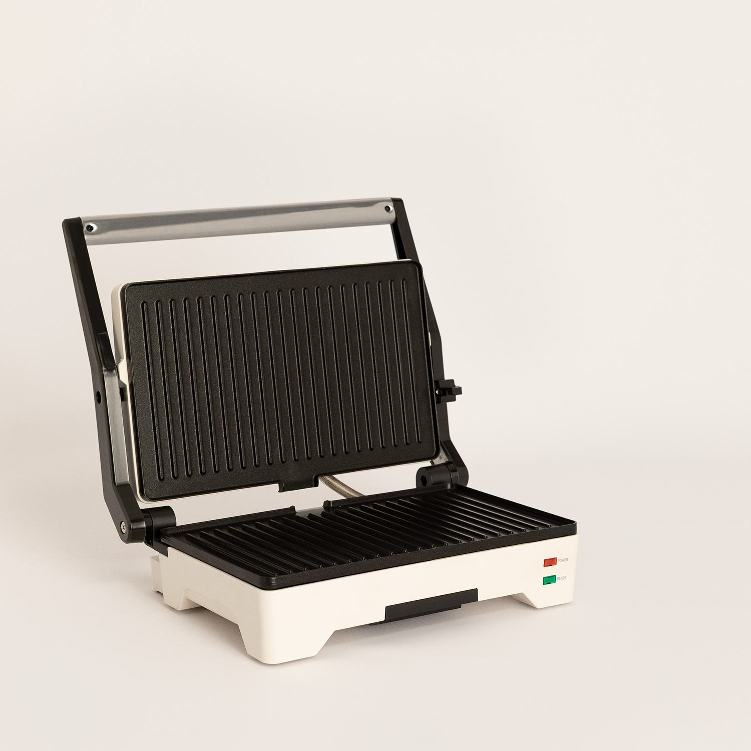 Un grill de contacto blanco y negro con placas abiertas y acanaladas sobre fondo claro.