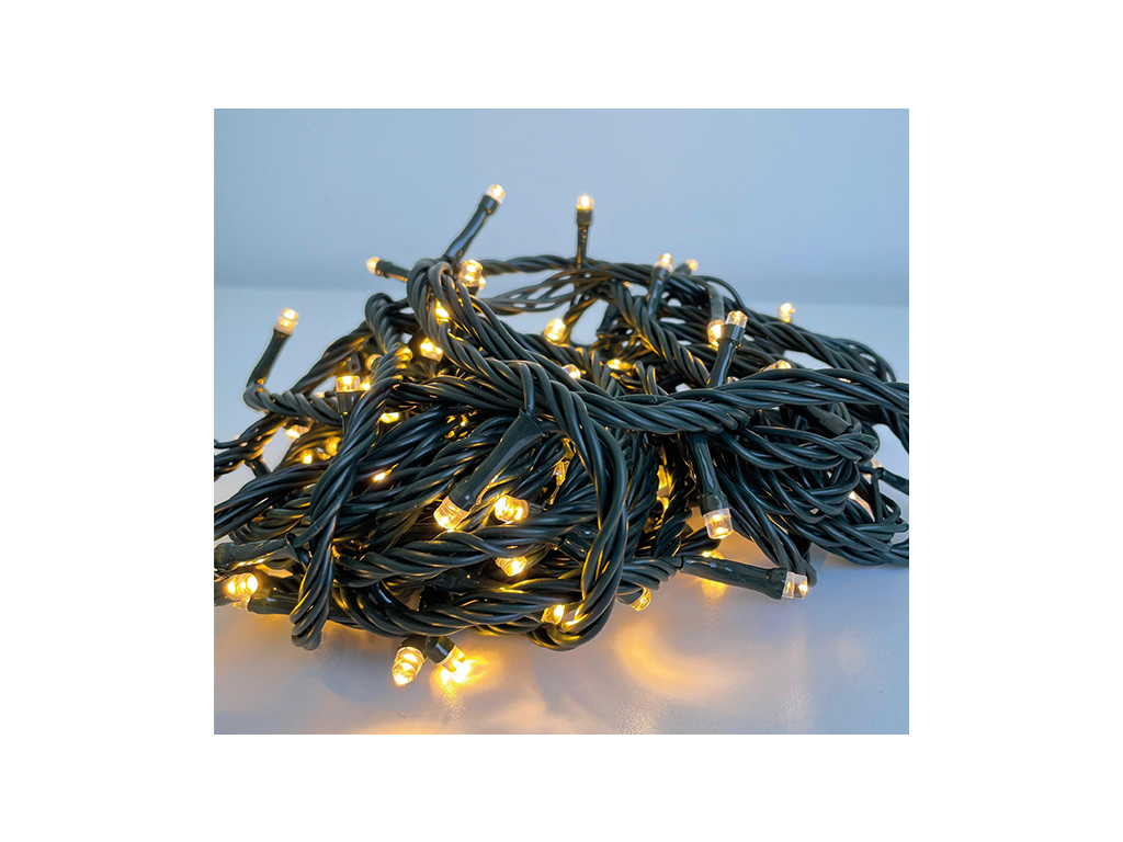 Un montón enredado de luces de cadena verdes con bombillas LED blancas cálidas en una superficie clara.