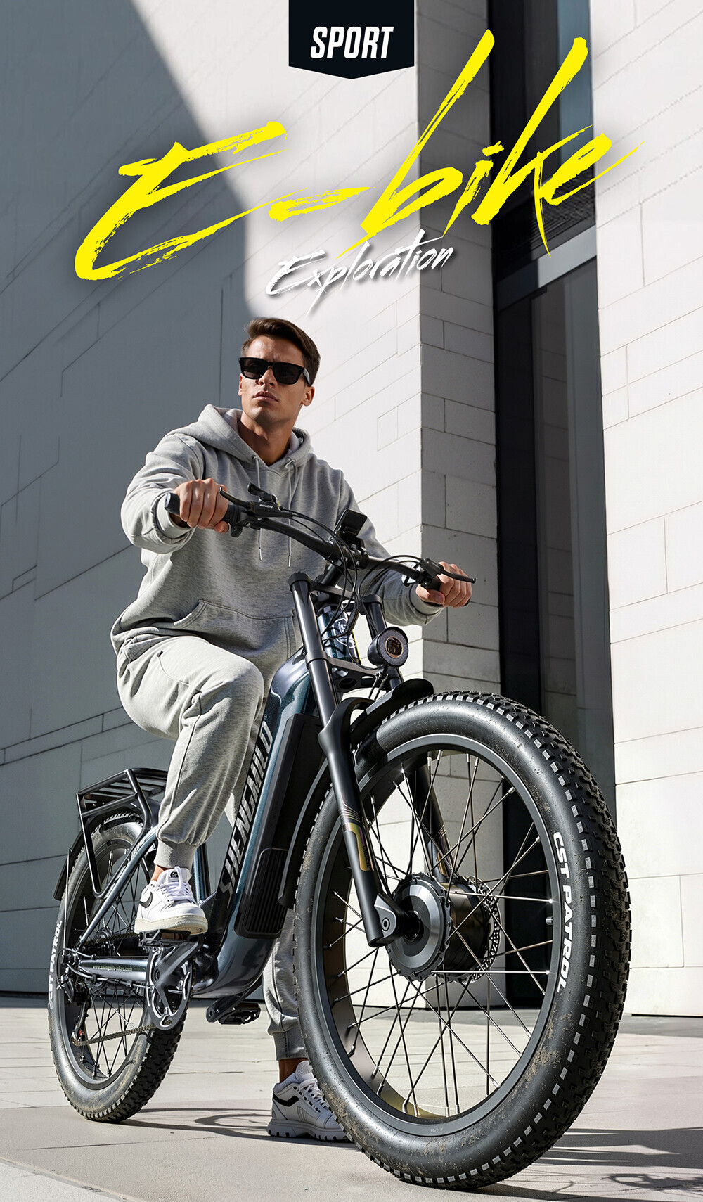 Ein Mann im grauen Hoodie sitzt auf einem schwarzen E-Bike vor einer hellen Fassade.