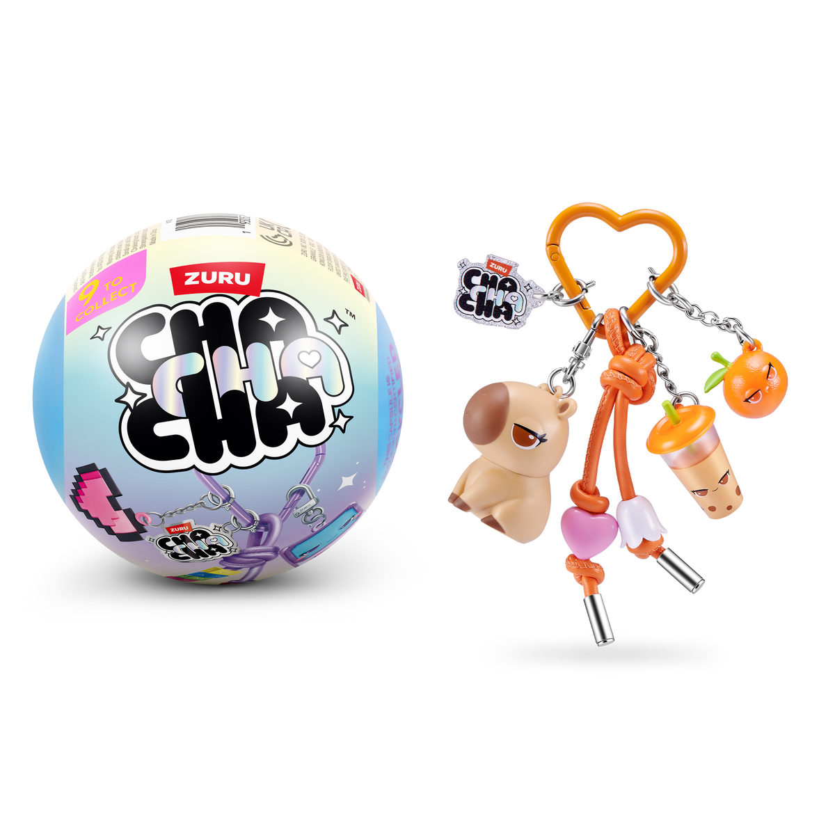 Una cápsula Zuru Cha Cha junto a un llavero de corazón naranja con dijes de animales, bebidas y frutas.