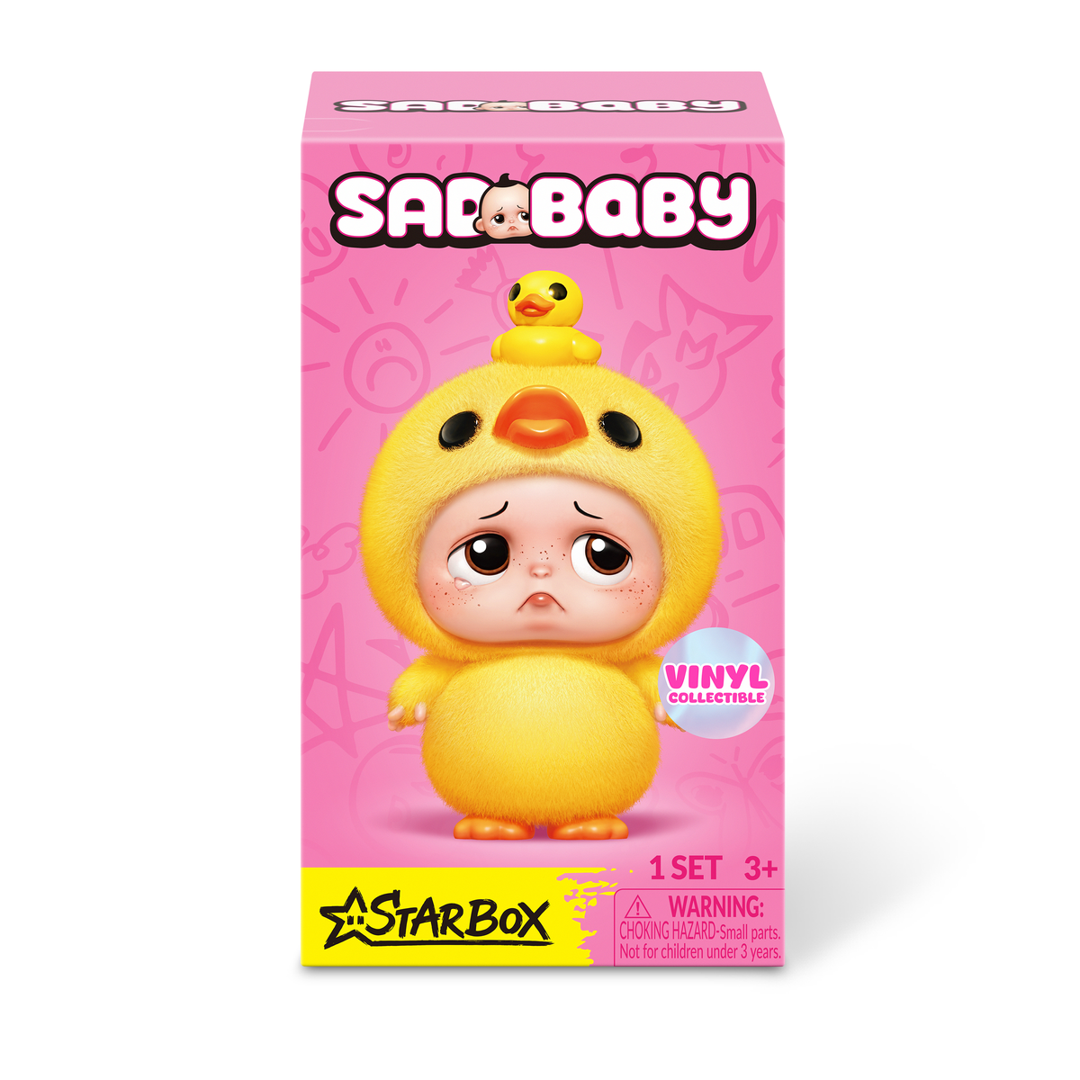 Caja rosa con una linda y triste muñeca de bebé en un disfraz de pato amarillo esponjoso con un pequeño pato en la cabeza.