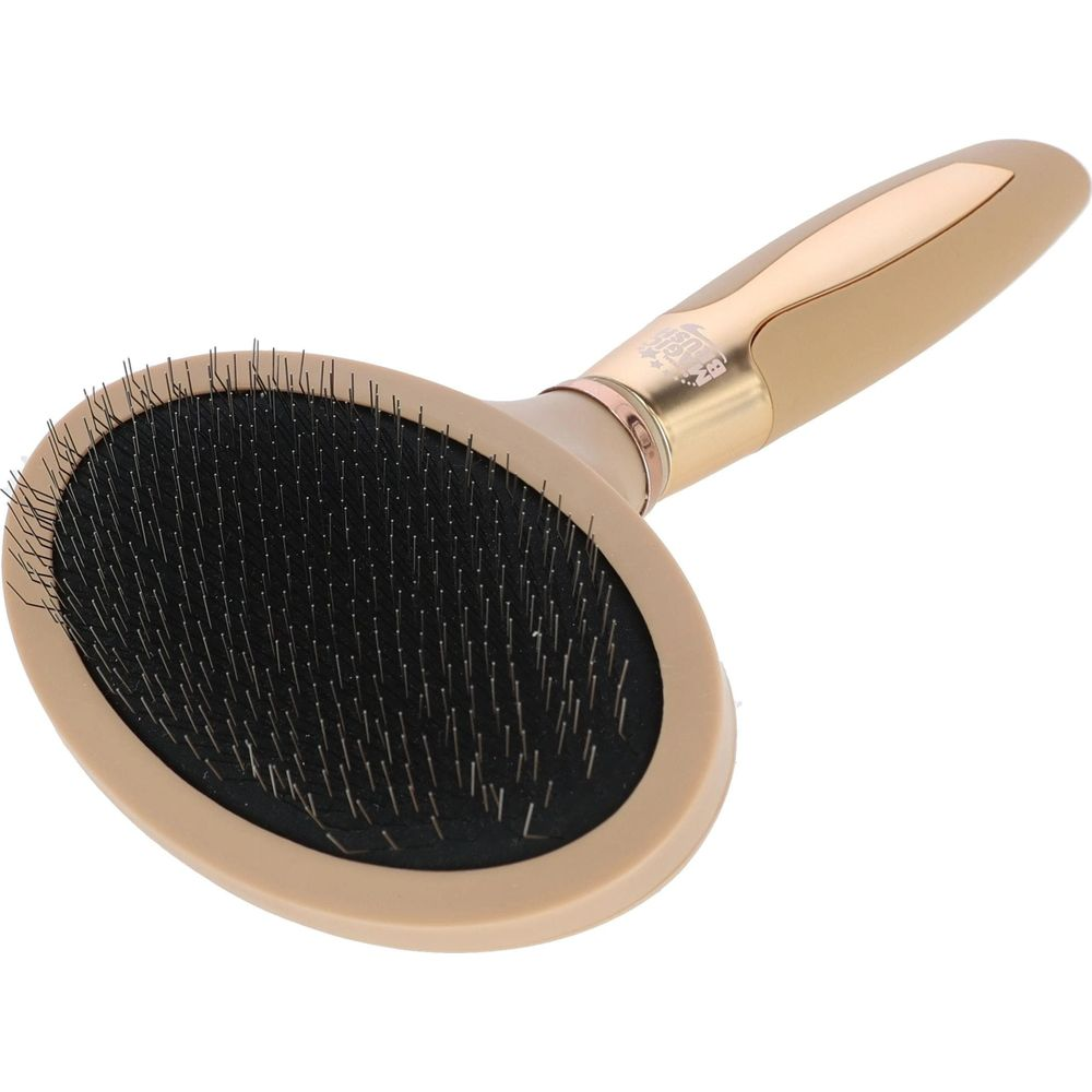 Eine ovale, beigefarbene Tierbürste mit feinen Metallstiften und goldenem Griff.