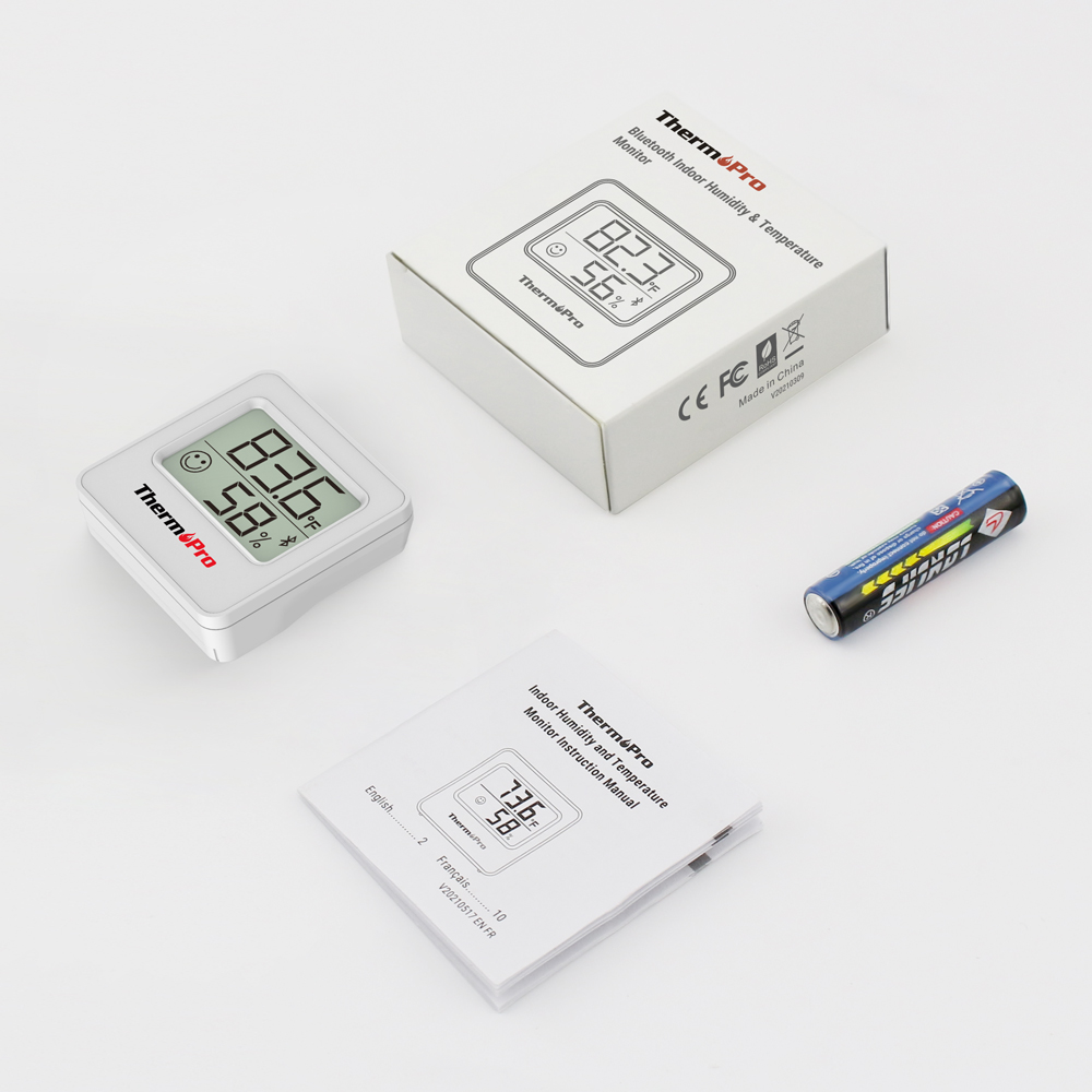 Ein ThermPro Feuchtigkeits- und Temperaturmonitor mit Verpackung, Anleitung und Batterie auf weißem Hintergrund.