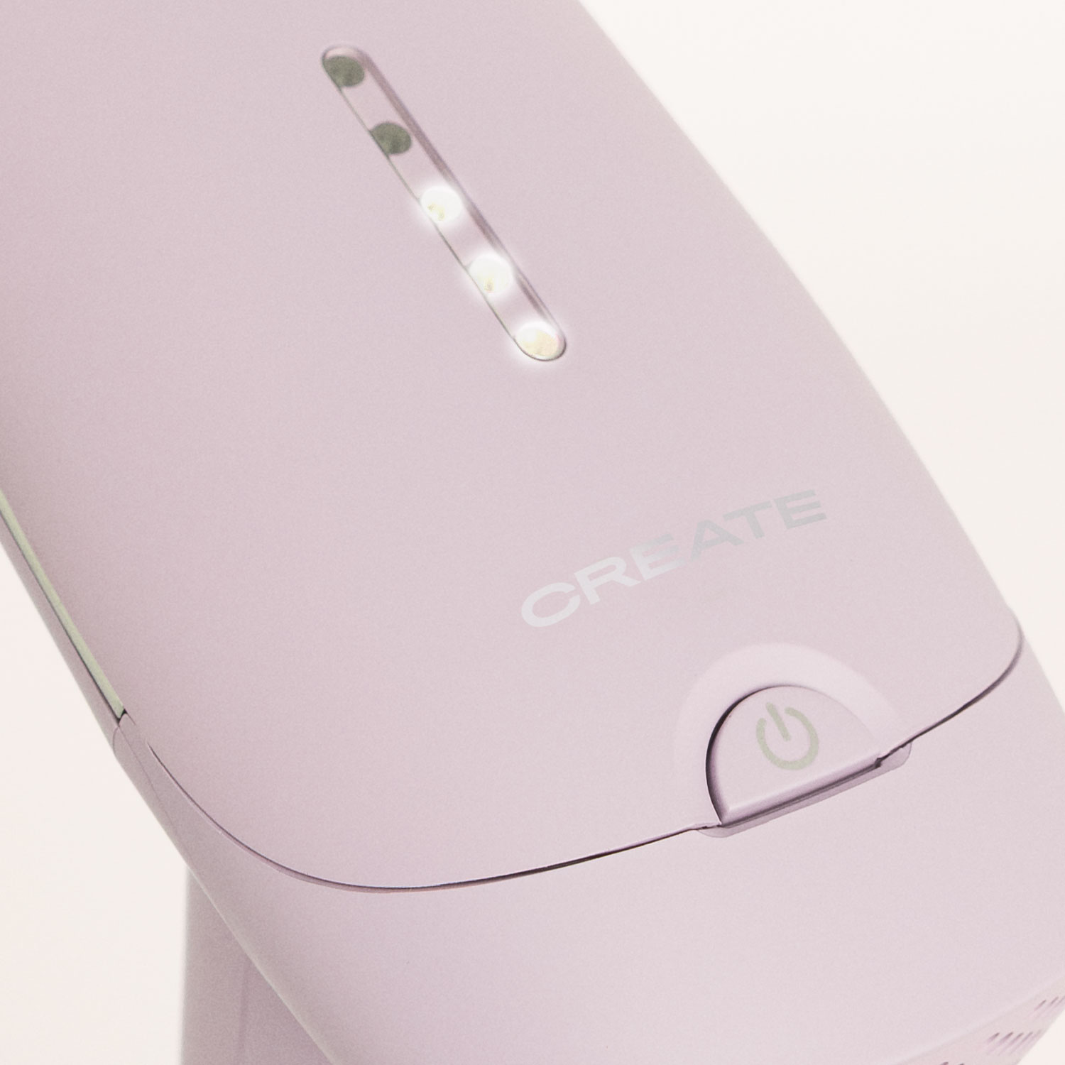 Primer plano de un vaporizador de prendas de mano de color morado claro con luces indicadoras encendidas.