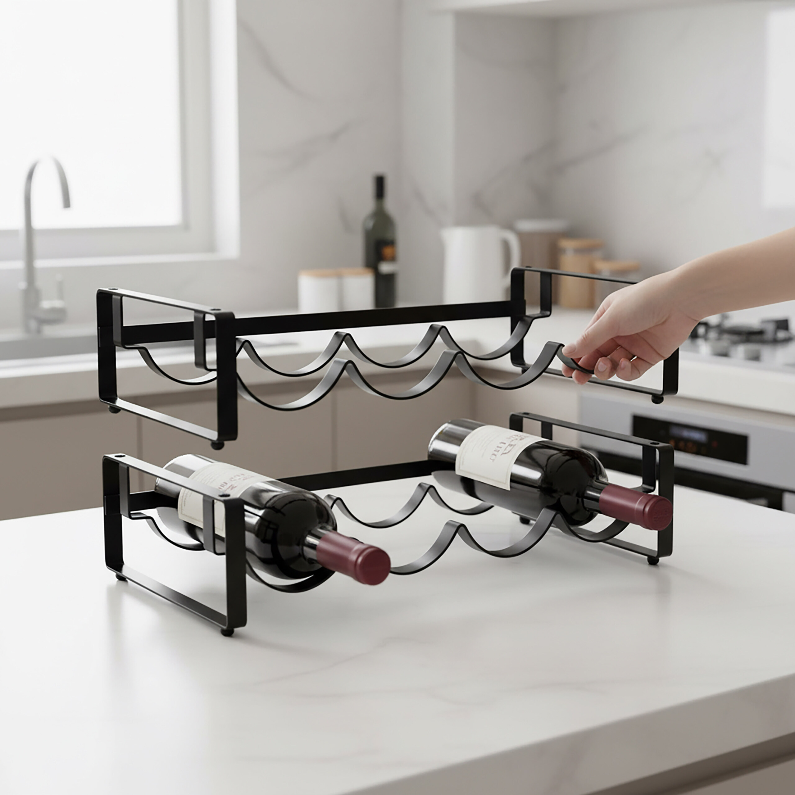 Eine Hand setzt ein schwarzes Weinregal auf ein anderes, das zwei Weinflaschen in einer modernen Küche hält.
