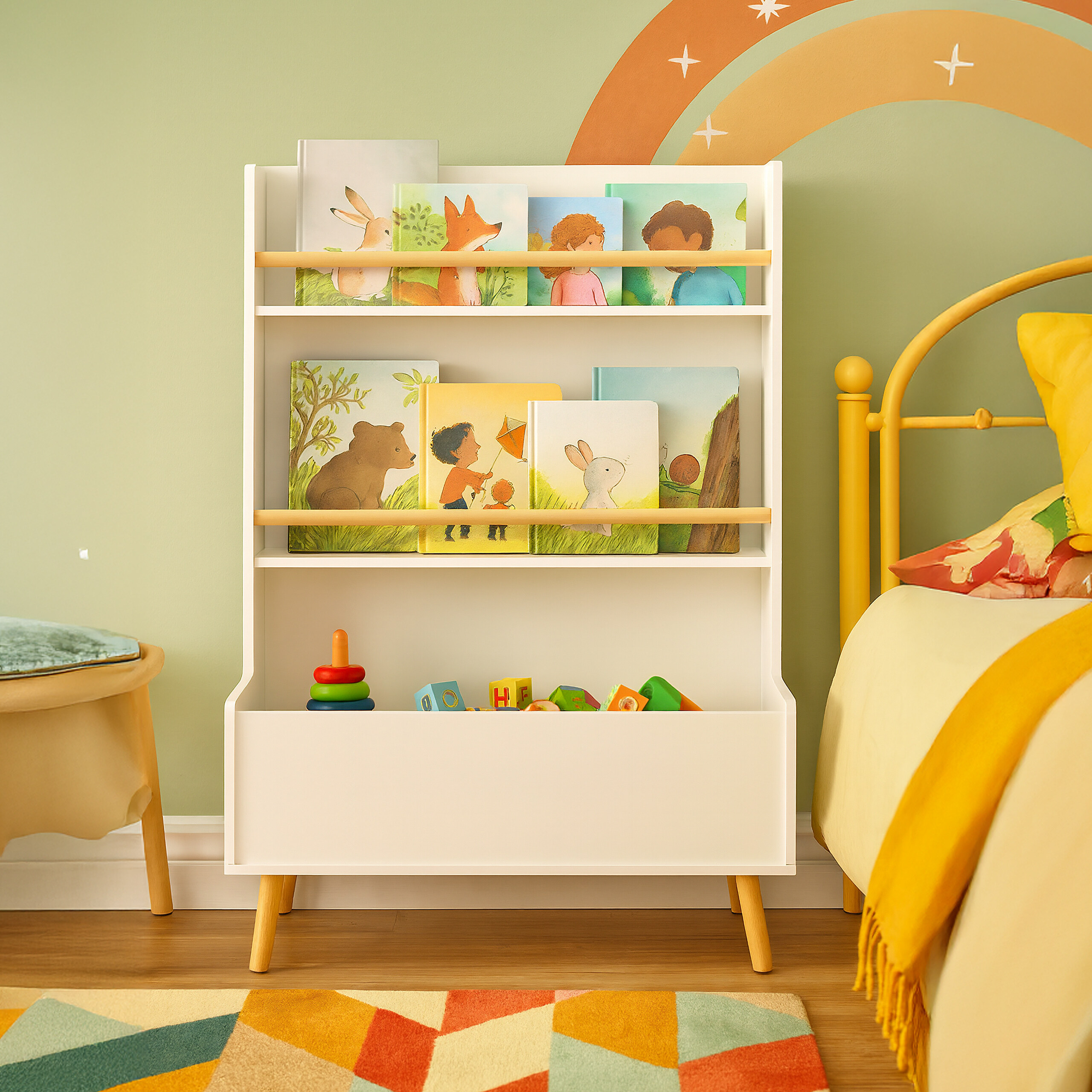 Weißes Kinder-Bücherregal voller illustrierter Bücher und Spielzeug in einem bunten Zimmer mit Regenbogenwand.