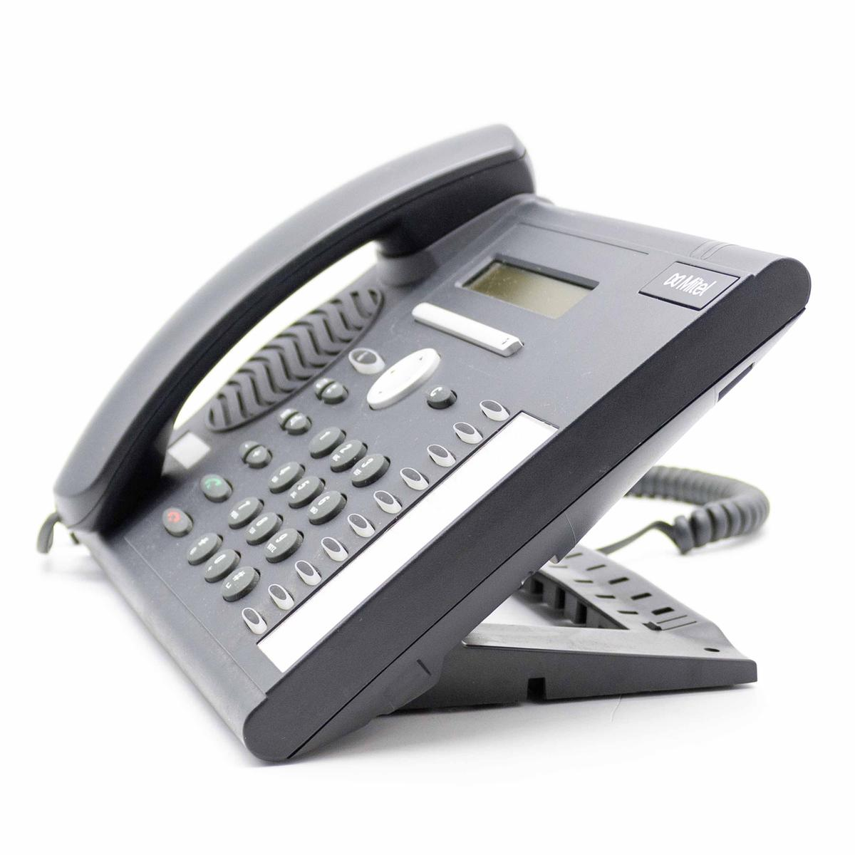 Un telefono da tavolo Mitel nero su sfondo bianco, con tastiera e ricevitore.