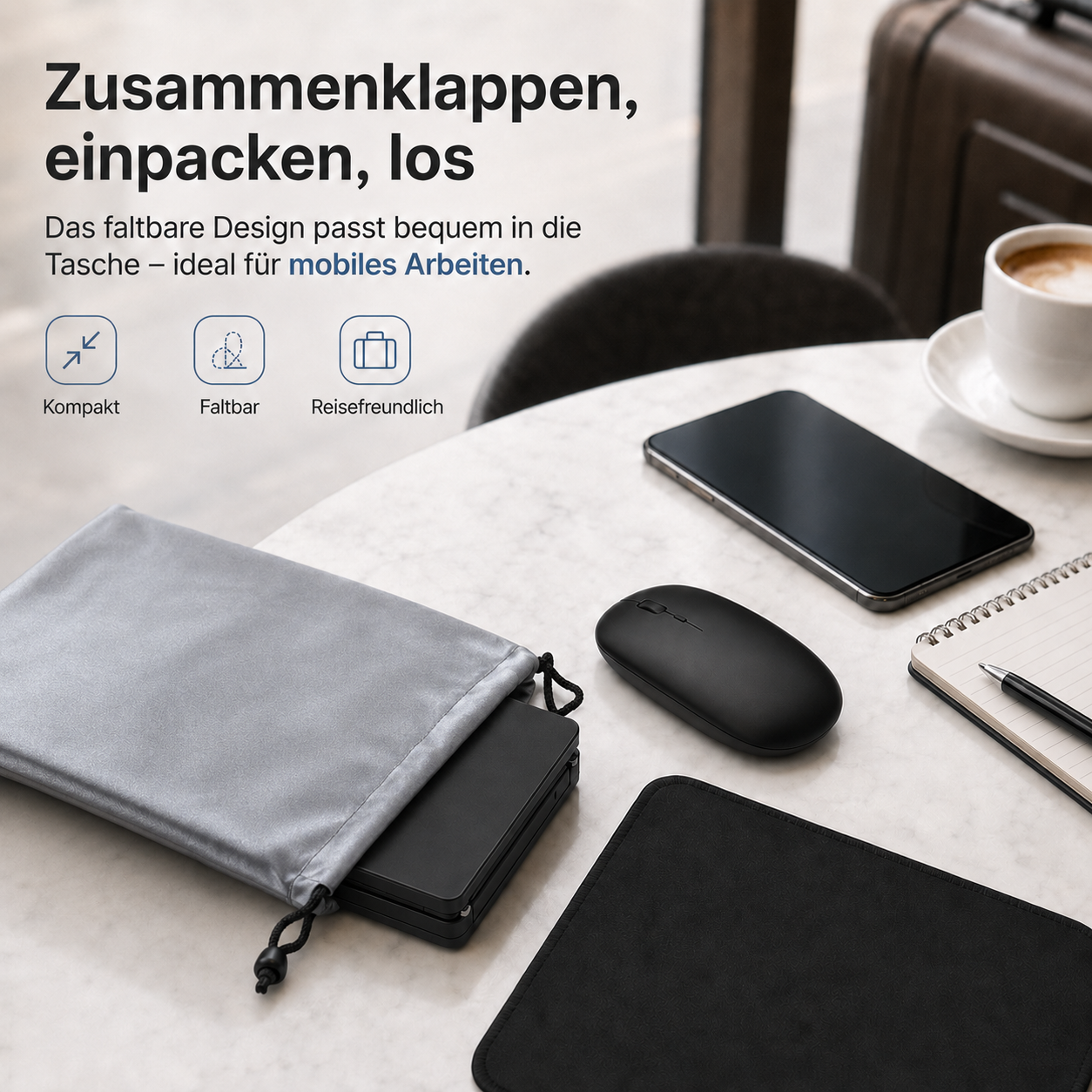 Ein faltbares Gadget, eine Maus und ein Smartphone liegen auf einem Tisch neben Kaffee und Notizbuch.