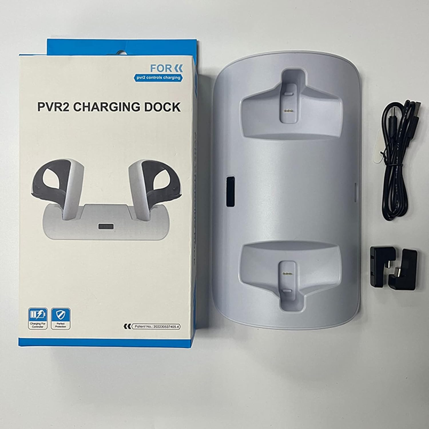 PVR2-Ladestation mit Box, Ladekabel und Adaptern auf weißem Tisch.