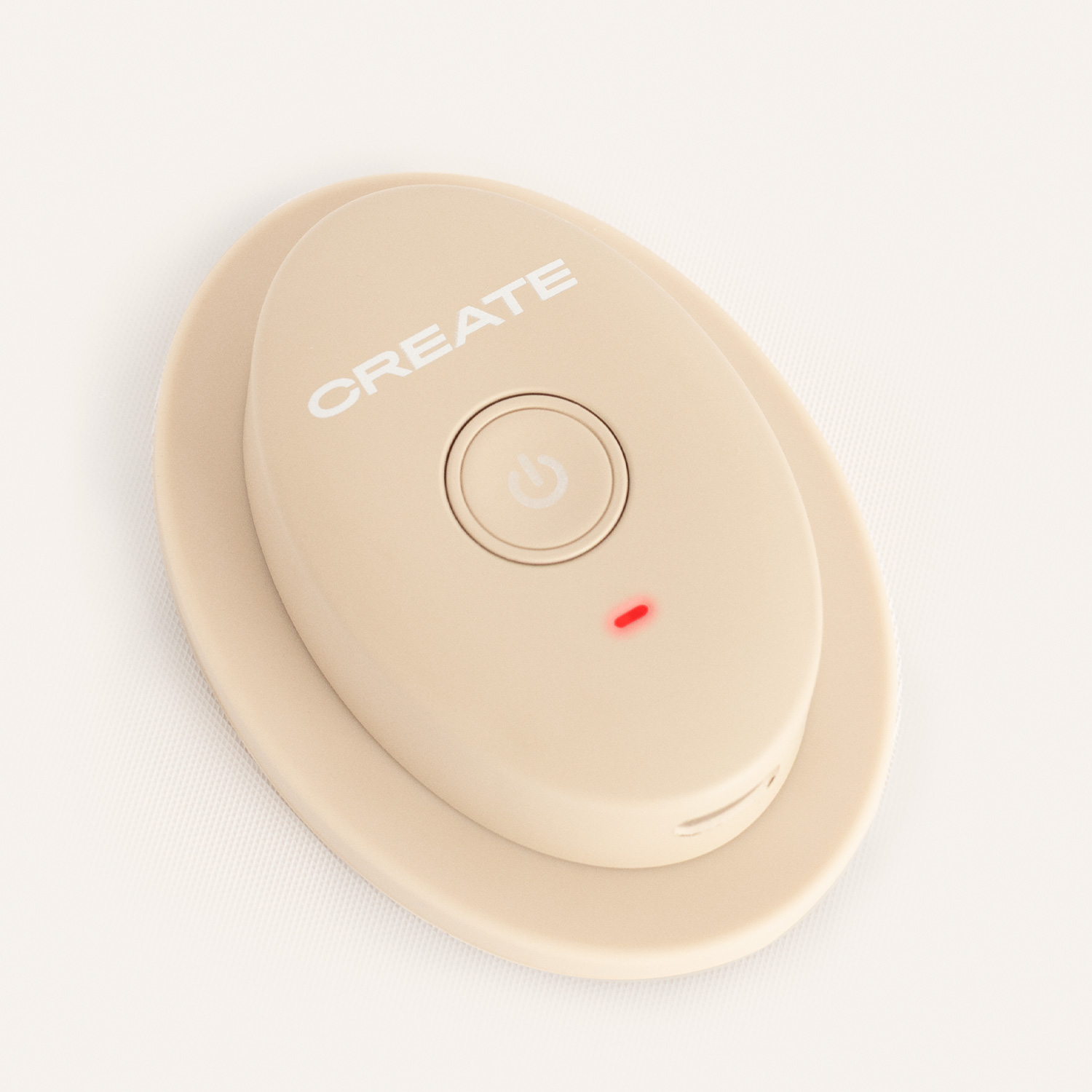 Un dispositivo ovalado beige con la palabra CREATE, un botón de encendido y un LED rojo brillante sobre fondo blanco.