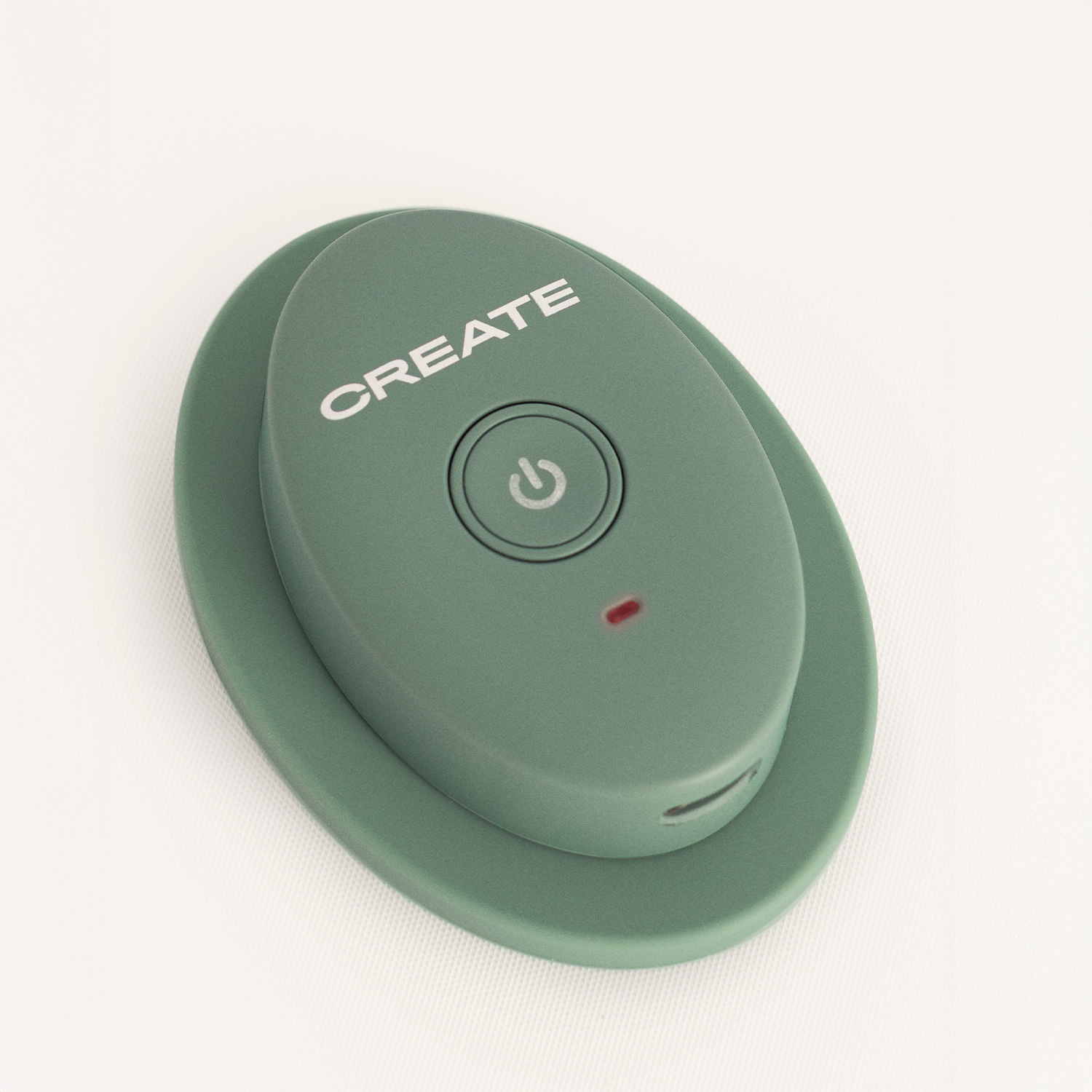 Un botón de control remoto Create verde ovalado con un icono de encendido y LED rojo sobre fondo claro.