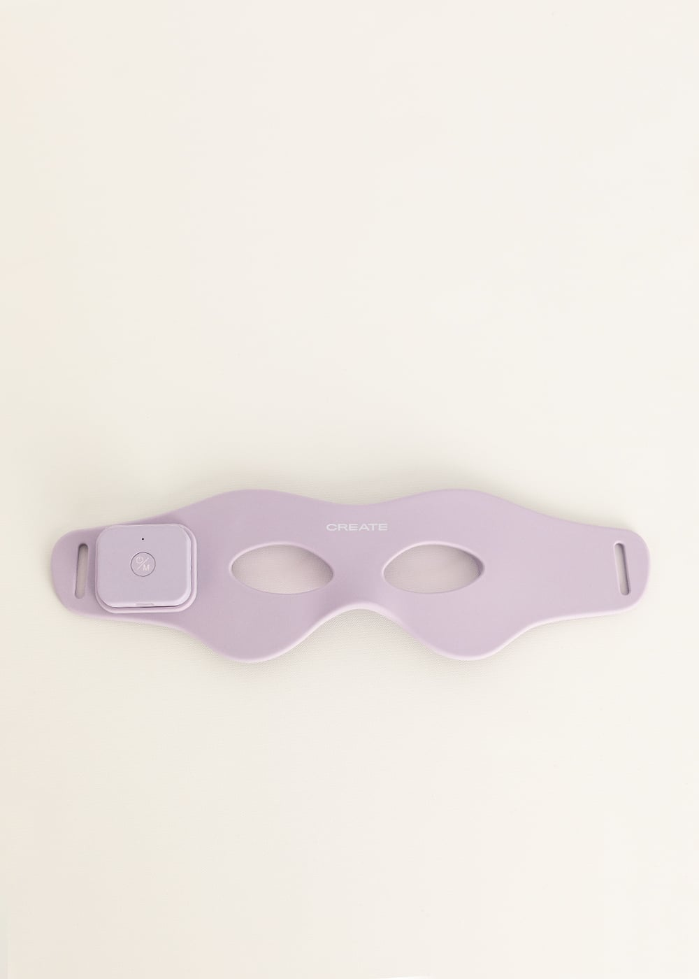 Un masajeador de ojos electrónico de color morado claro con dos aberturas redondas sobre fondo blanco.