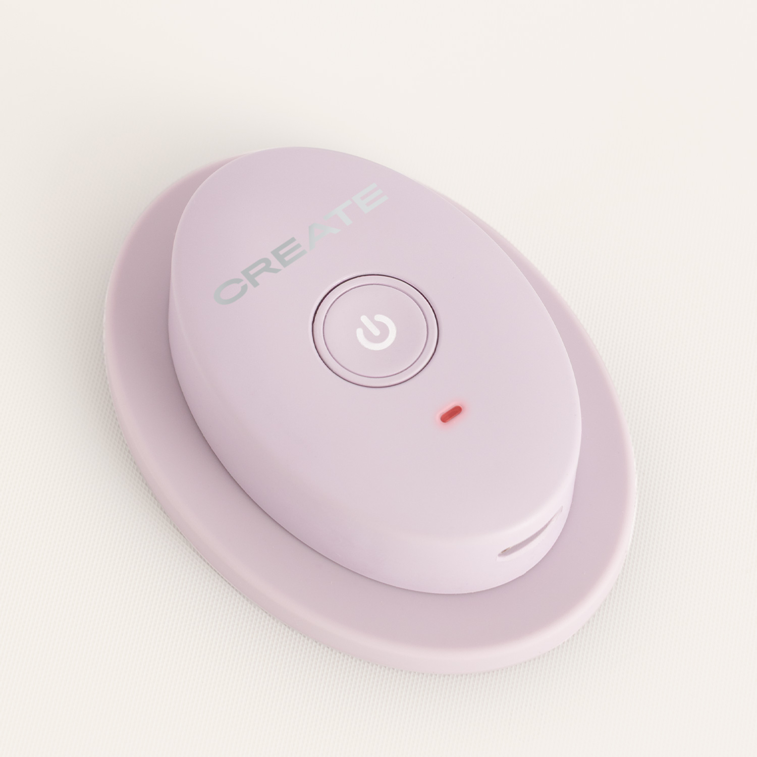 Un dispositivo ovalado de color morado claro con un botón de encendido redondo y una luz indicadora roja sobre fondo blanco.