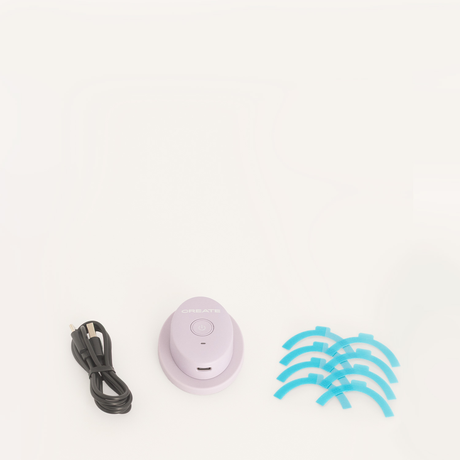 Un cable USB negro, un dispositivo Create morado y ocho tiras adhesivas azules sobre fondo blanco.