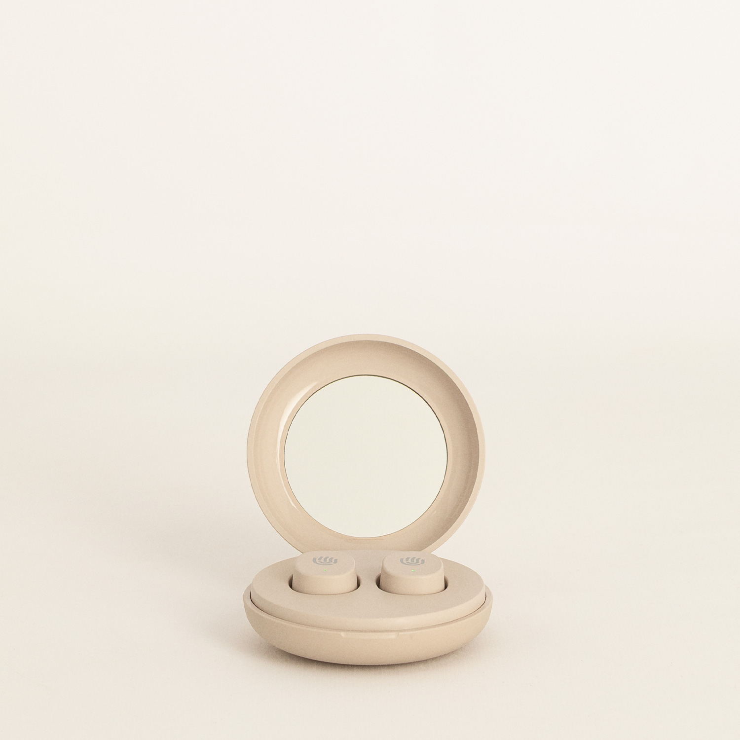 Estuche de carga inalámbrico redondo y beige con tapa abierta y espejo integrado, sobre un fondo claro.
