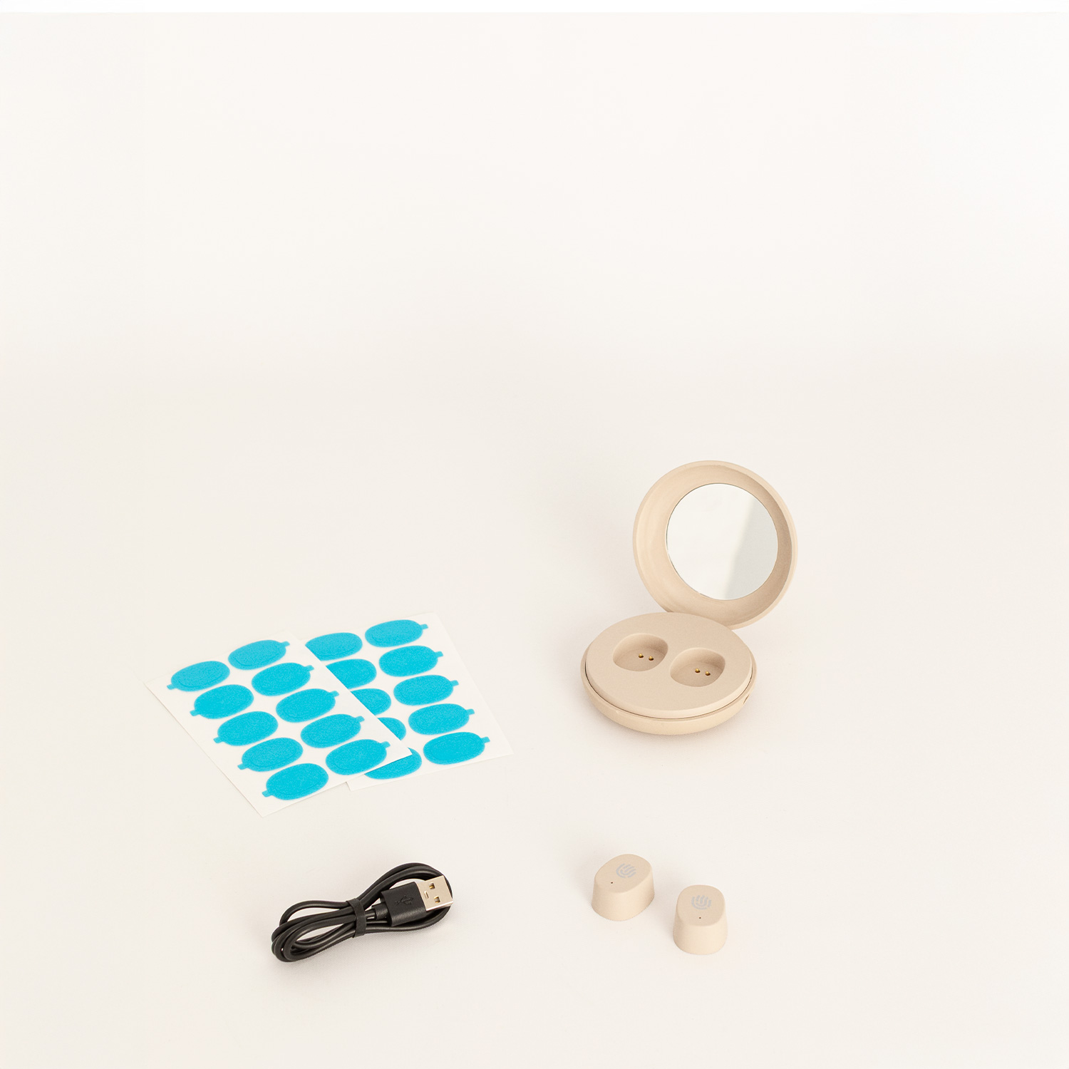 Estuche de carga beige con espejo, dos auriculares beige, un cable USB negro y dos hojas de parches ovalados azules.