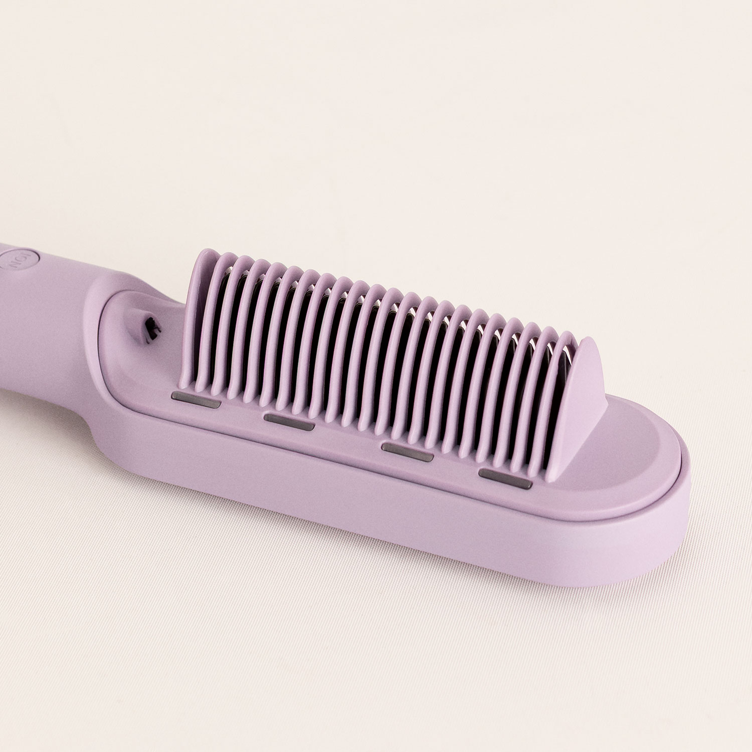 Un cepillo alisador de pelo morado con cerdas alineadas sobre fondo claro.