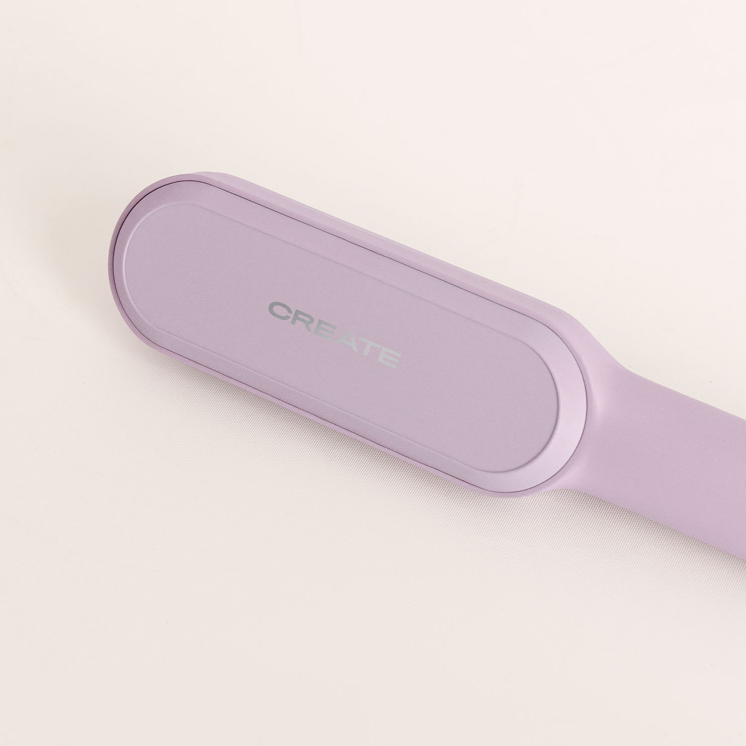 Una plancha de pelo morada con la marca CREATE sobre fondo blanco.