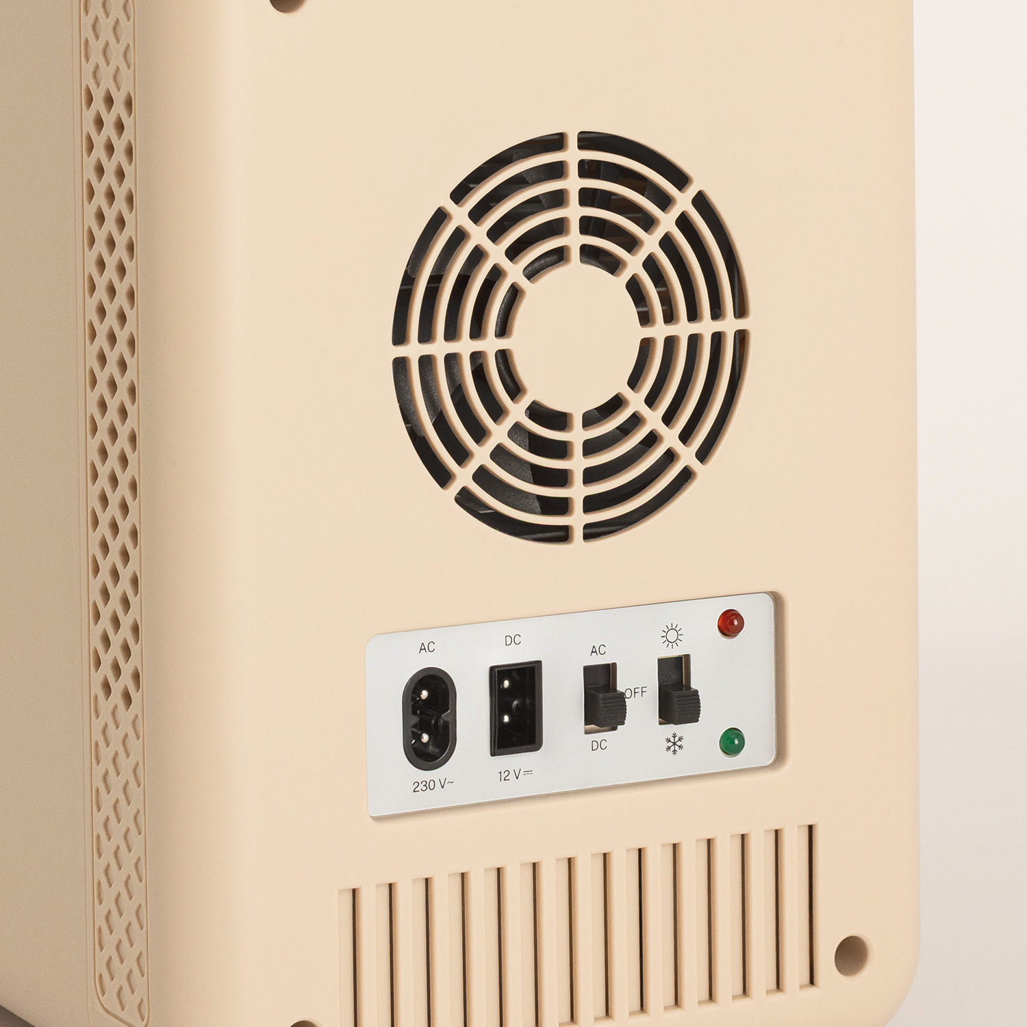 Panel trasero de una mini nevera beige con rejilla de ventilación, puertos y interruptores.