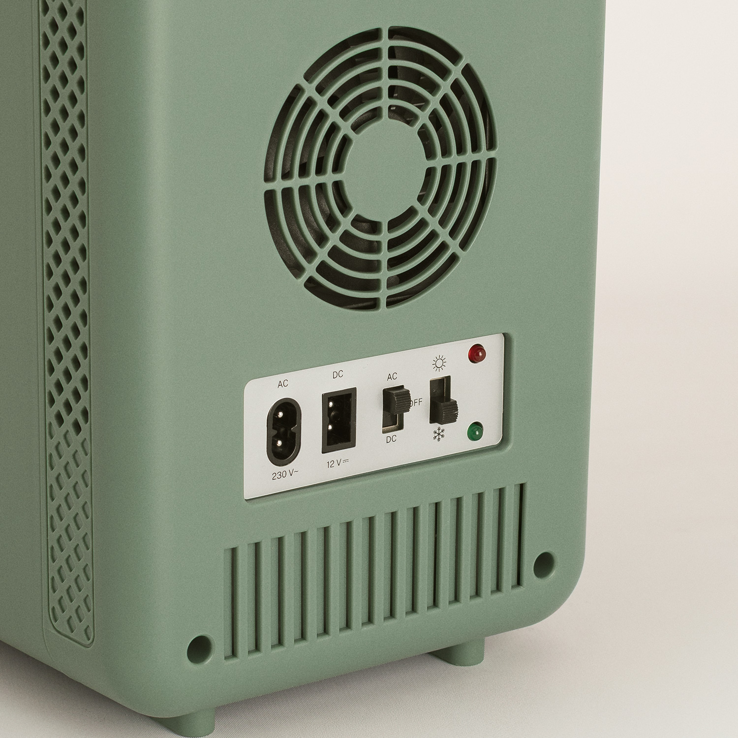 La parte trasera de un dispositivo verde menta con rejilla de ventilación, enchufes e interruptores.