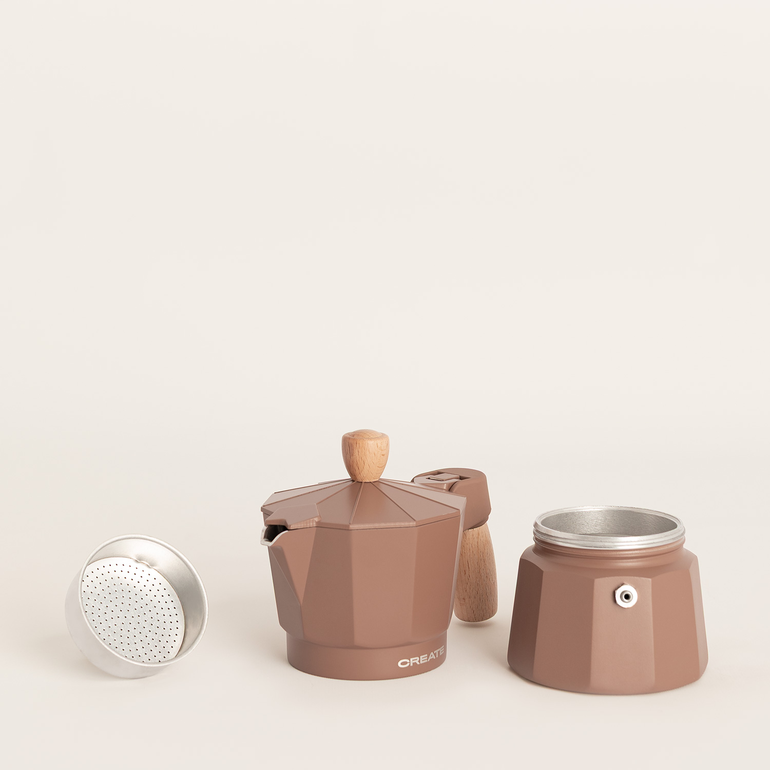 Una cafetera moka marrón con detalles de madera está desmontada sobre un fondo claro.