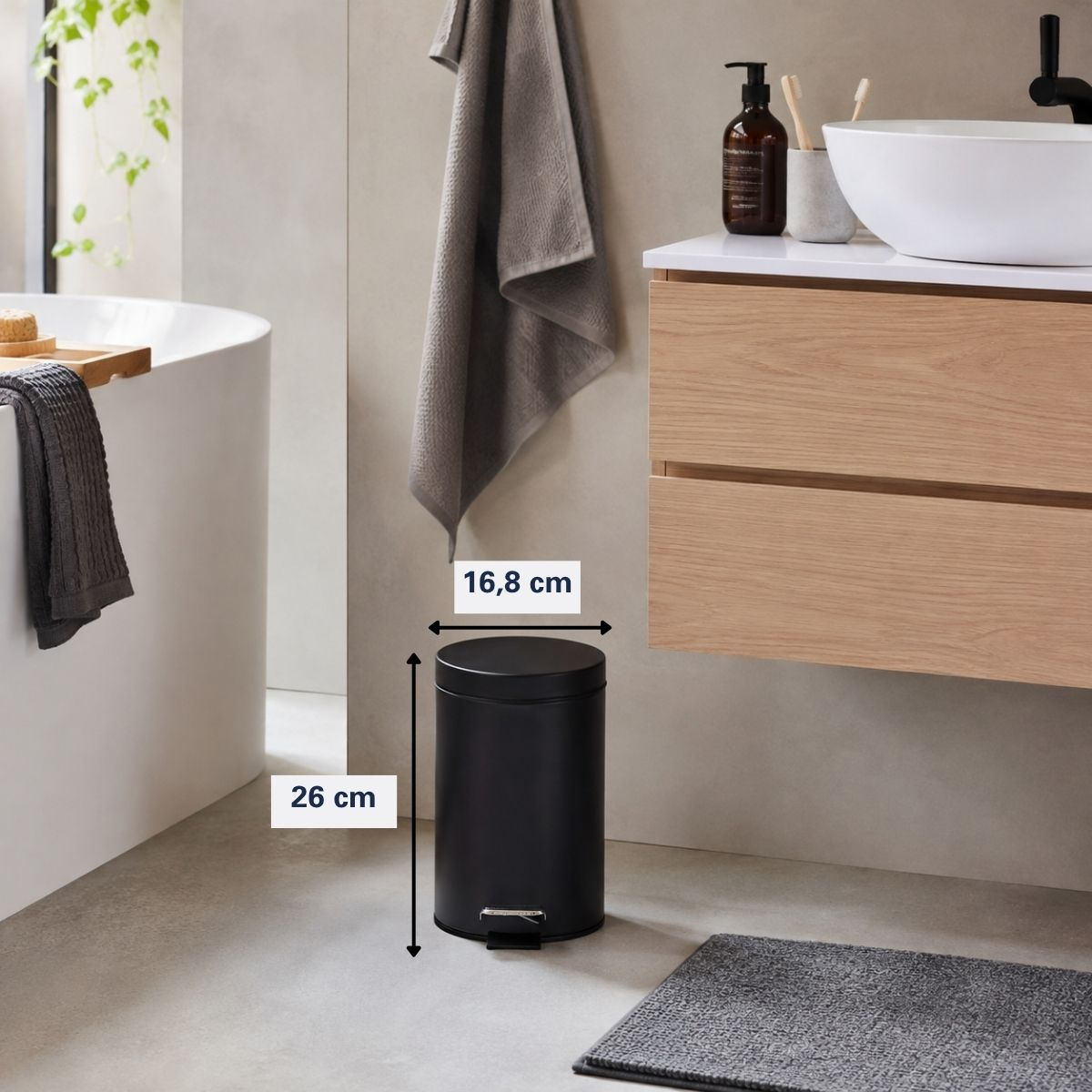A black pedal bin in a modern bathroom, with dimensions of 16.8 cm width and 26 cm height shown.