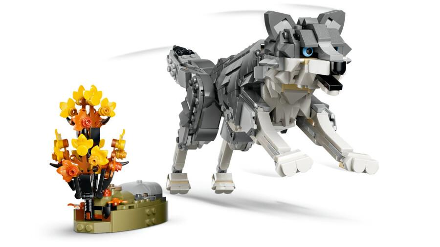 Yandaki küçük bir sonbahar bitkisiyle koşan bir Lego kurt.