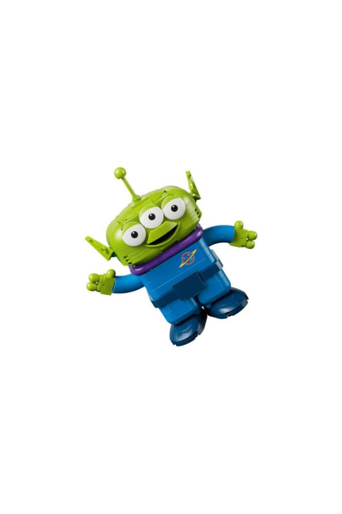 Üç gözlü, mavi elbiseli ve kafasında anteni olan yeşil bir Lego uzaylı oyuncak.
