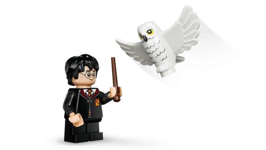 Beyaz arkaplanda asa tutan Harry Potter Lego figürü ve uçan beyaz baykuş.