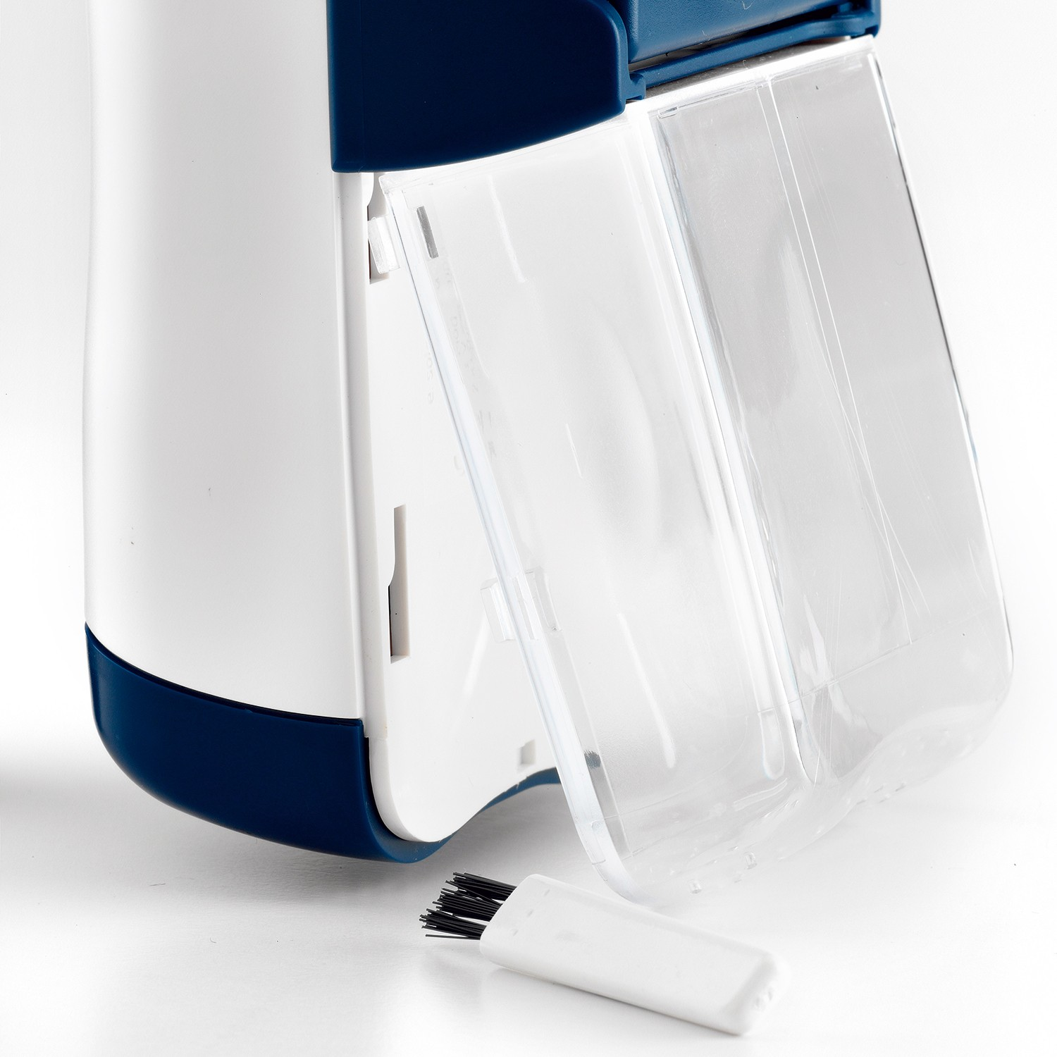 Un dispositivo blanco y azul con un compartimento transparente y un cepillo pequeño.
