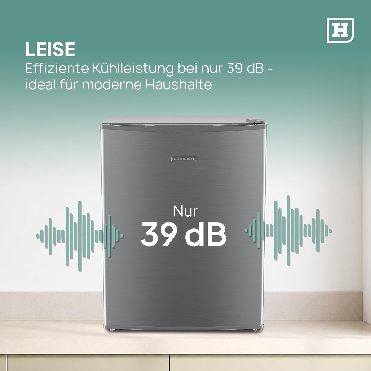 Ein silberner Kompaktkühlschrank auf einer Theke mit Schallwellen-Grafik für leisen Betrieb.