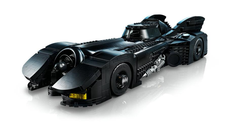 Filmden büyük siyah bir LEGO Batmobil, parlak beyaz bir yüzey üzerinde duruyor.