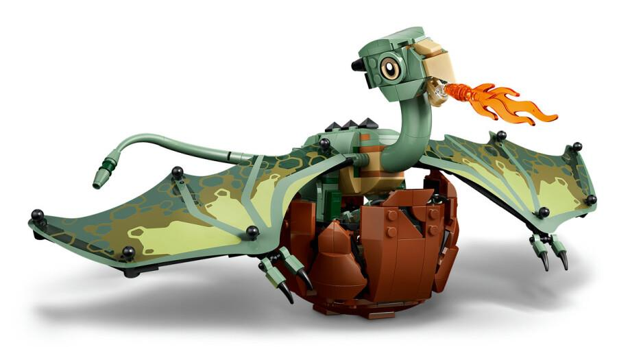 Kahverengi bir yumurtadan çıkan yeşil bir LEGO ejderhası turuncu ateş püskürtüyor.