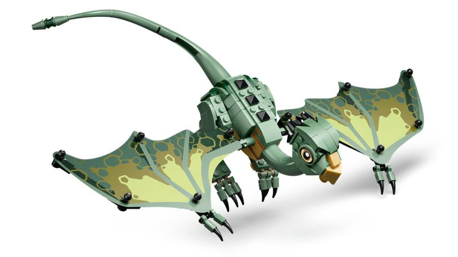 Beyaz arka planda büyük desenli kanatları ve uzun kuyruğu olan yeşil bir LEGO pterodaktil dinozor oyuncak.