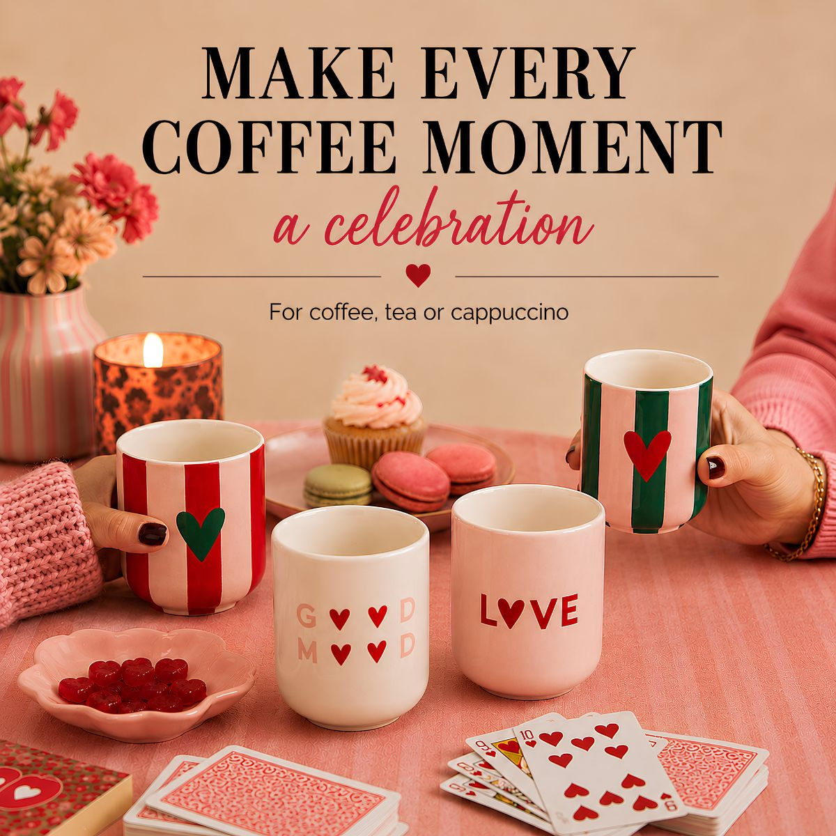 Colorful coffee mugs with hearts, sweets, and playing cards on a table.