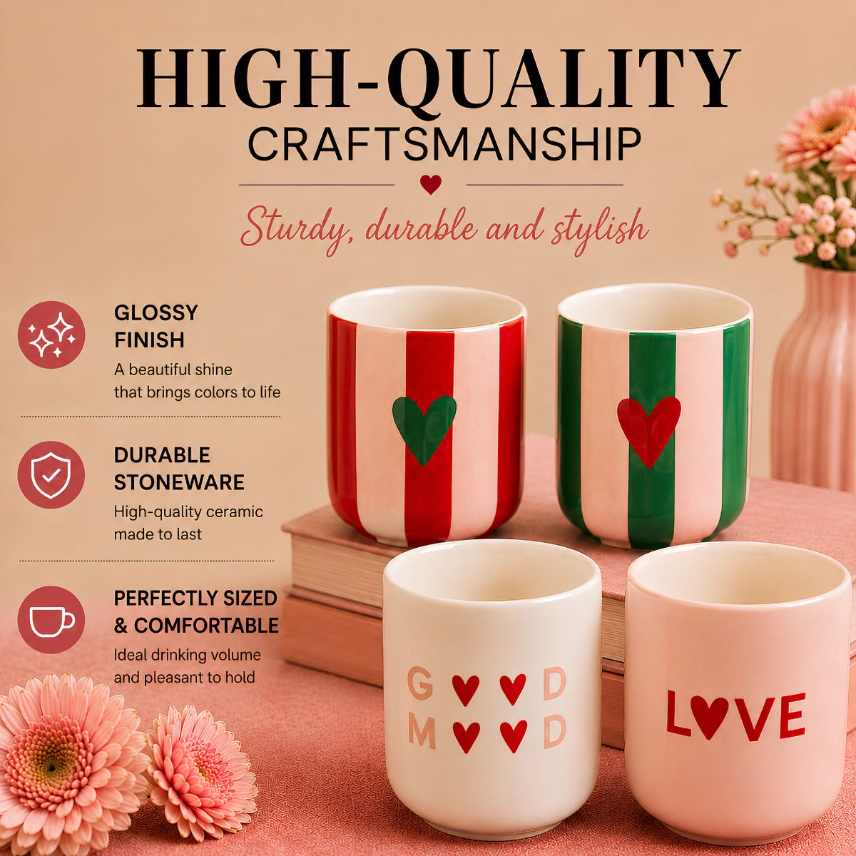 Four colorful ceramic mugs with heart designs, standing on books beside pink flowers against a beige background.
