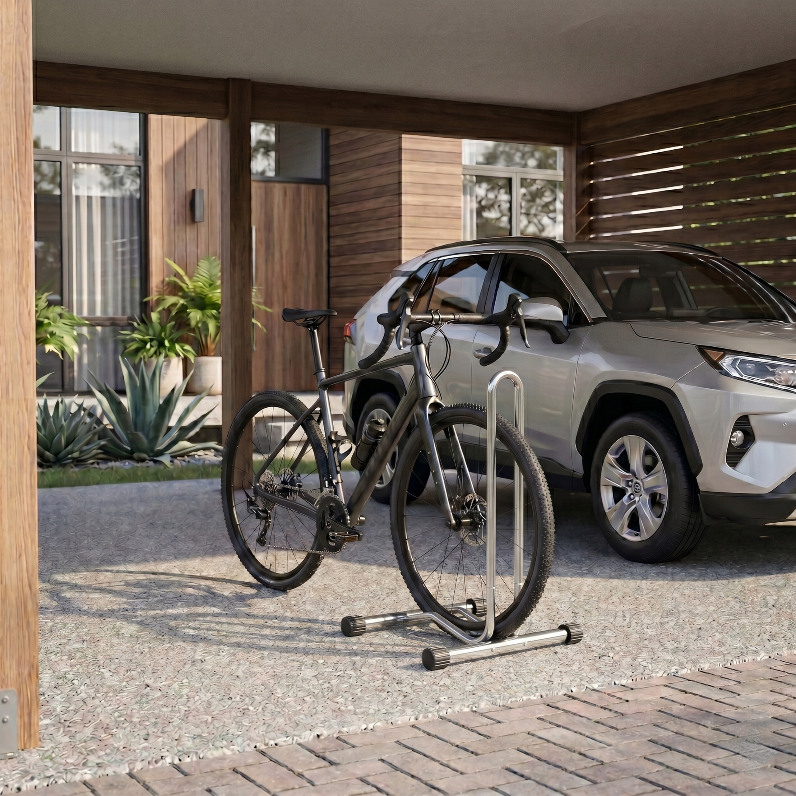 Ein schwarzes Fahrrad in einem Metallständer auf einer Betonauffahrt, mit einem silbernen Auto und einem modernen Haus.