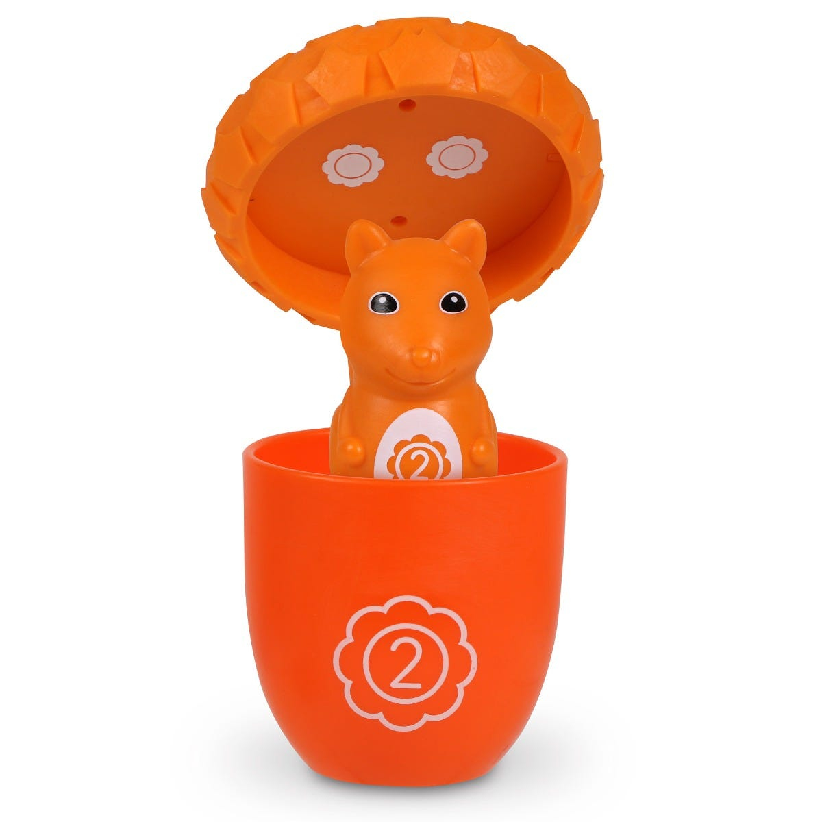 Ein orangefarbenes Spielzeughörnchen springt aus einem Becher mit der Zahl zwei vor weißem Hintergrund.