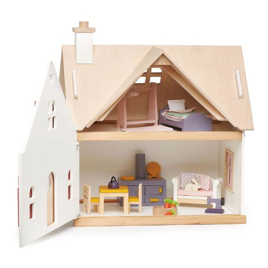 Ein zweistöckiges Puppenhaus aus Holz mit Möbeln und geöffneter weißer Tür vor weißem Hintergrund.