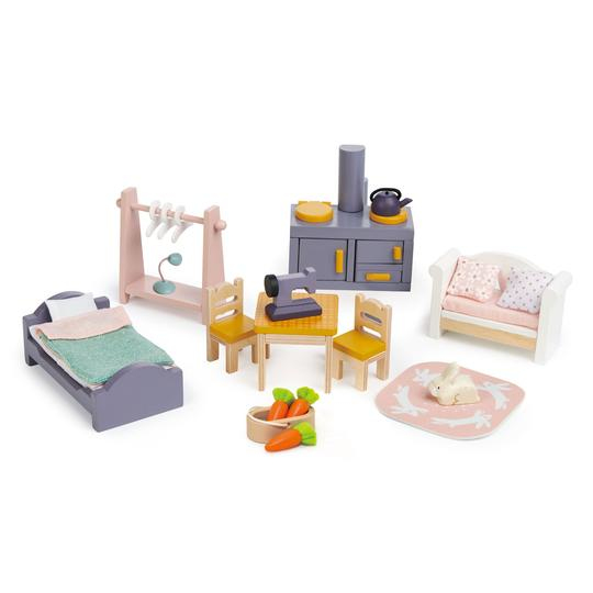 Ein Set aus Puppenhausmöbeln aus Holz, bestehend aus Bett, Herd, Sofa, Tisch, Stühlen und Zubehör auf weißem Hintergrund.