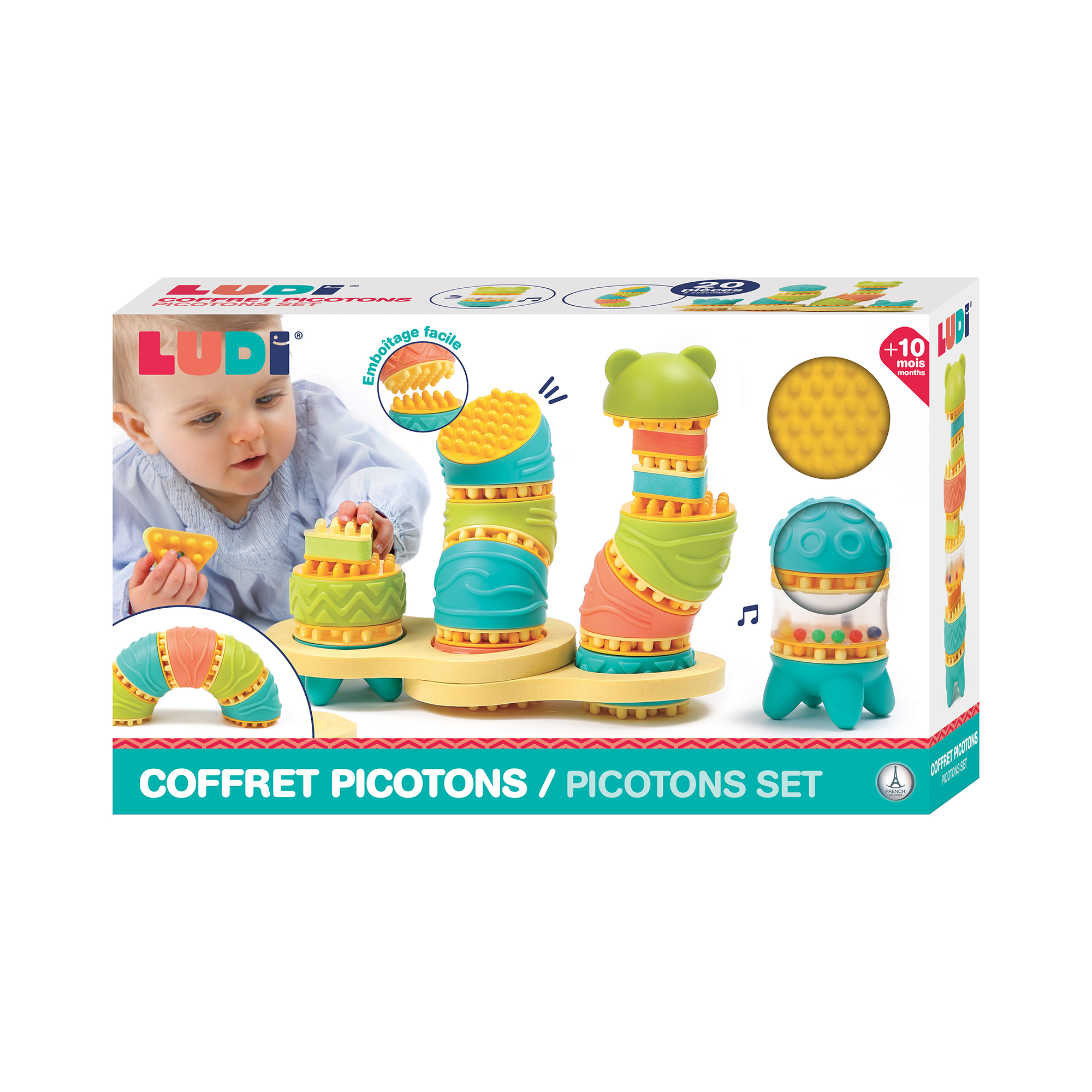 Verpackung eines bunten Baby-Stapelspielzeugs mit Noppen, Kleinkind baut im Hintergrund.