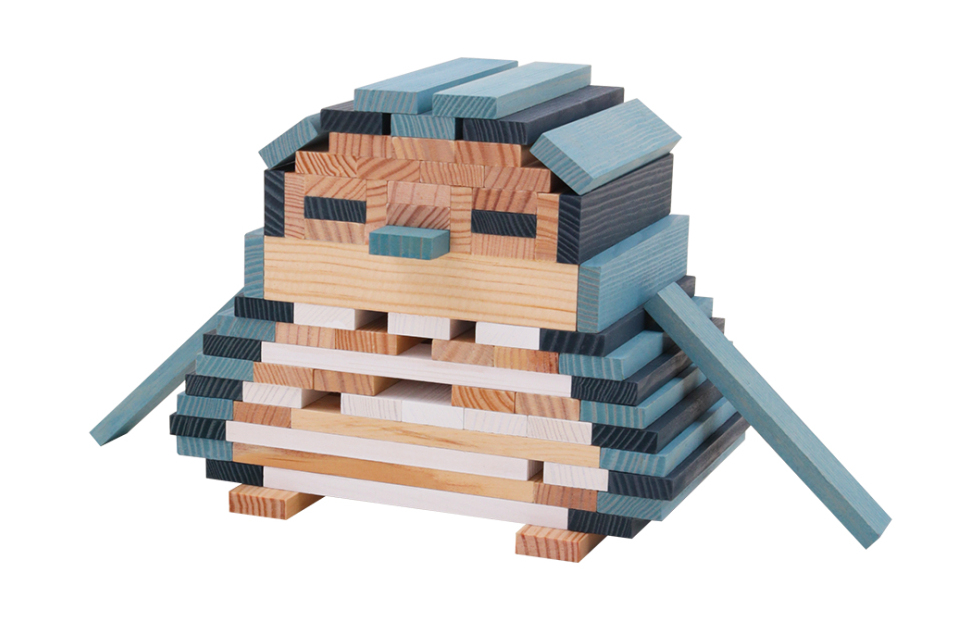 Eine Pinguinfigur ist sorgfältig aus bunten Holzklötzen auf weißem Hintergrund gebaut.