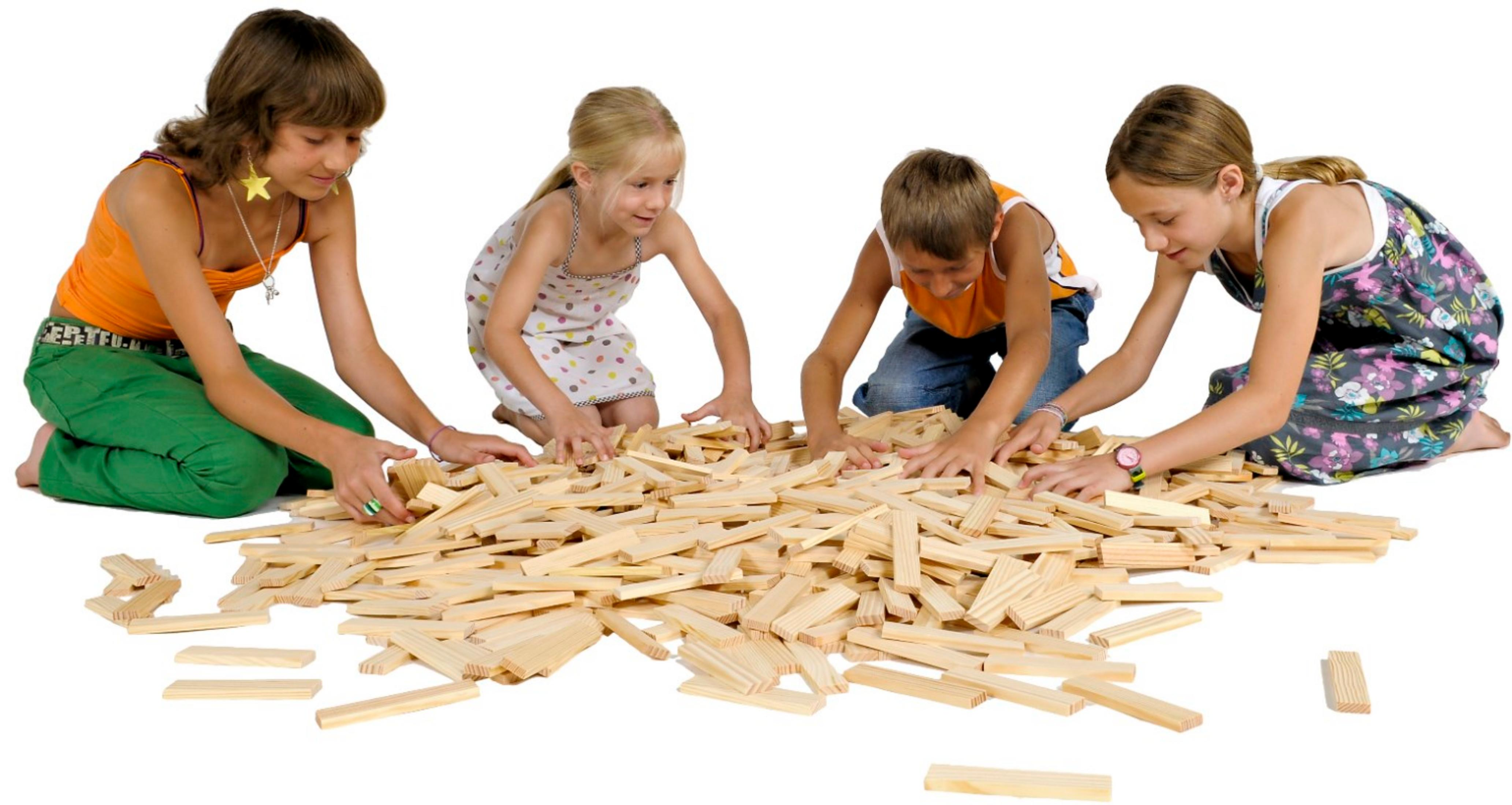 Vier Kinder knien auf dem Boden und spielen zusammen mit einem großen Haufen kleiner Holzklötze.
