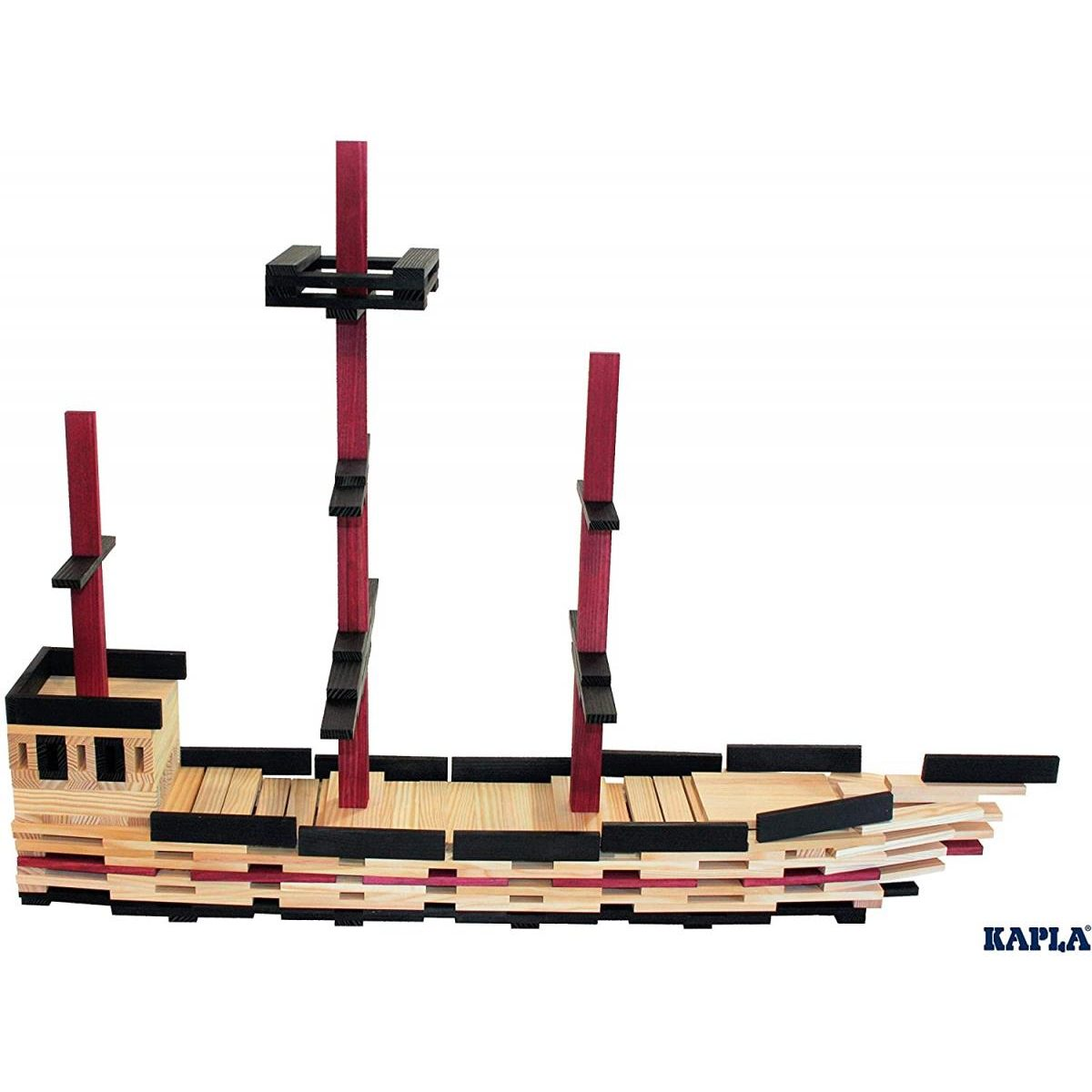 Ein Holzschiffsmodell aus Kapla-Planken mit roten Masten und schwarzen Akzenten vor weißem Hintergrund.