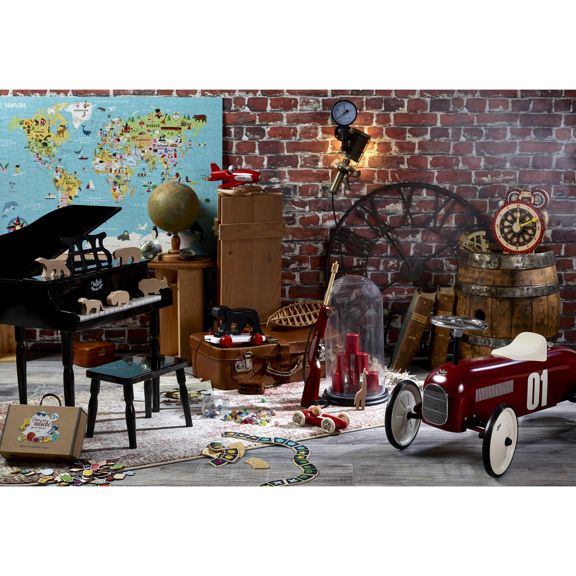 Altes Spielzimmer mit rotem Spielzeugauto, Klavier, Weltkarte, Globus und Backsteinwand.